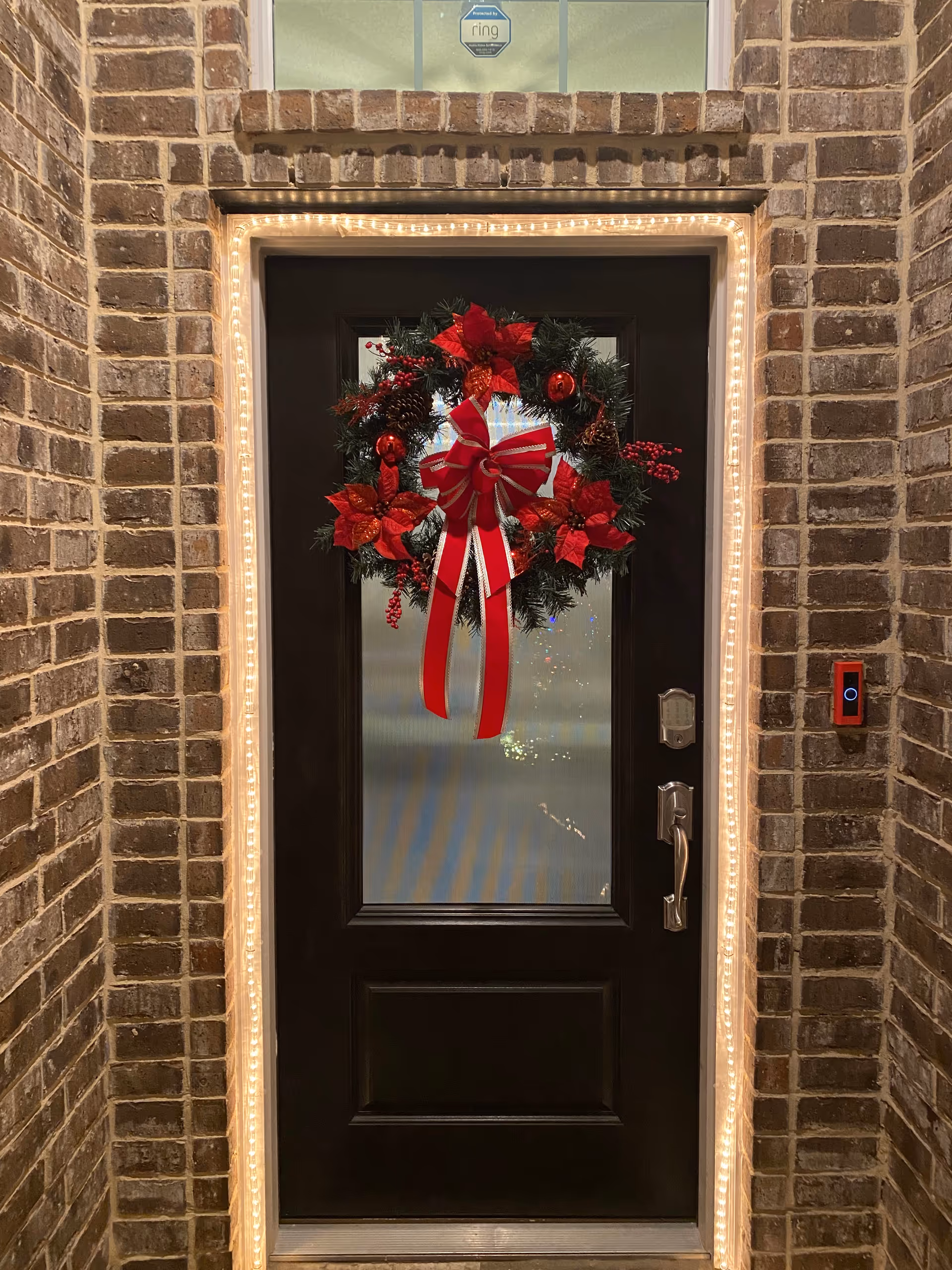 Angels of Hope Care Home entrance with a wreath, holiday lights, and keypad.