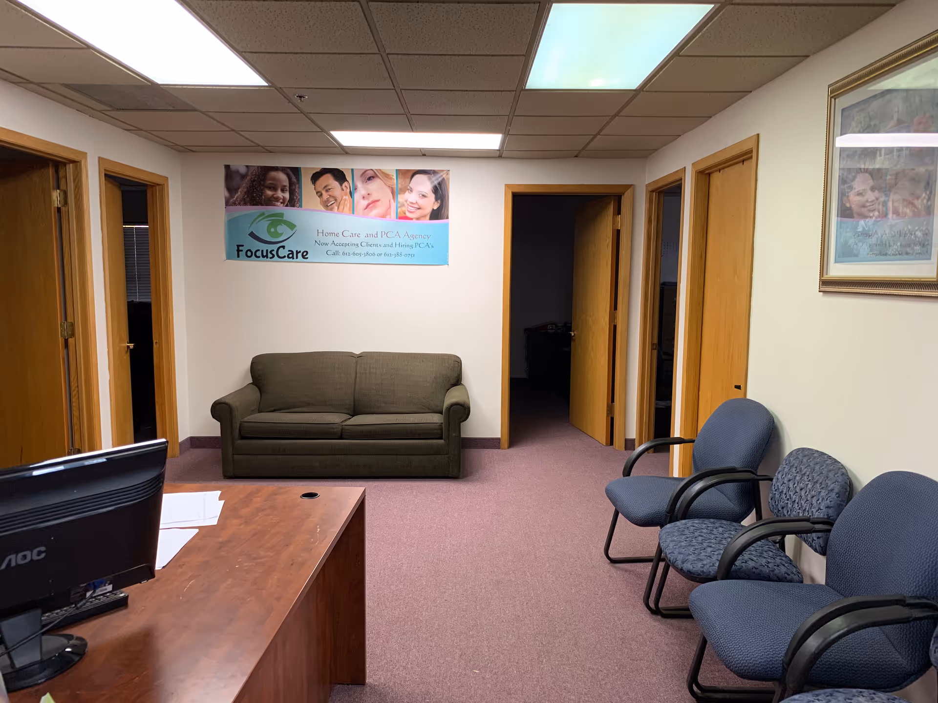 Reception area with desk, couch, and blue chairs in FocusCare office.