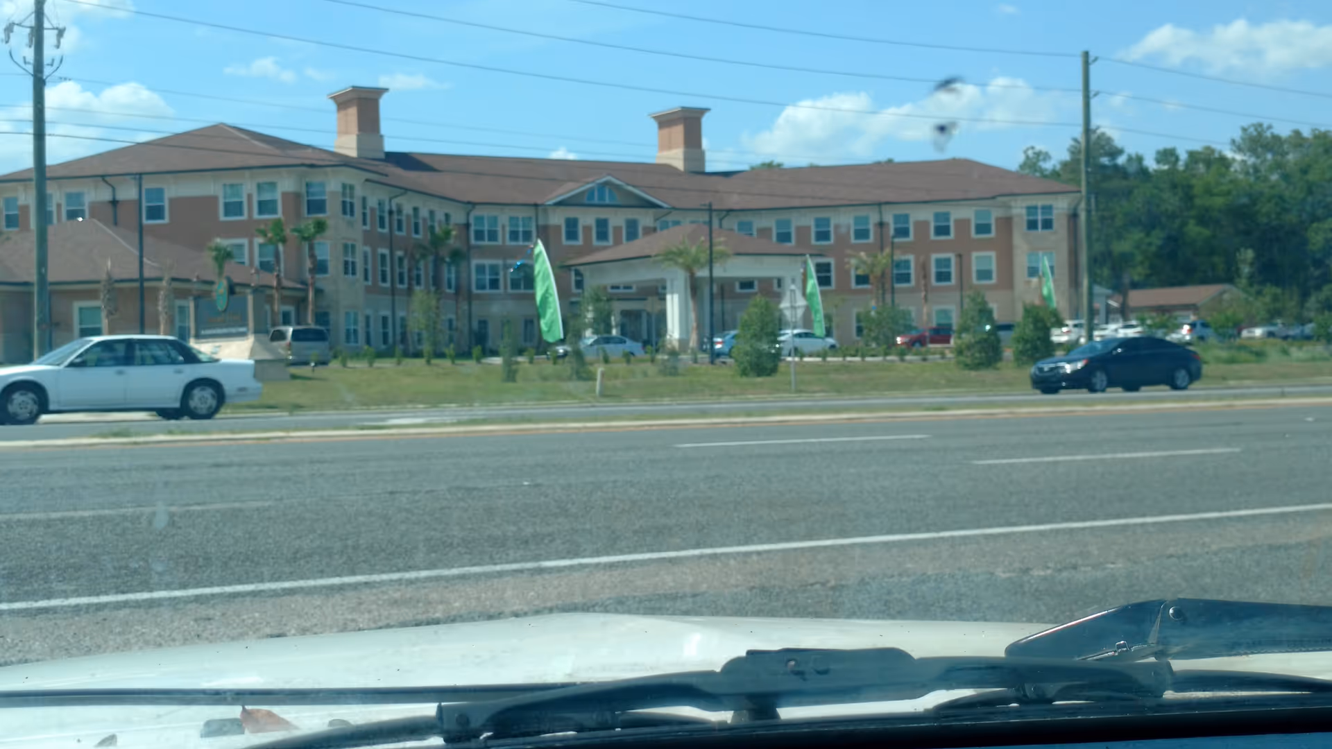 Exterior view of Canterfield of Ocala, a multi-wing senior living building along a road.