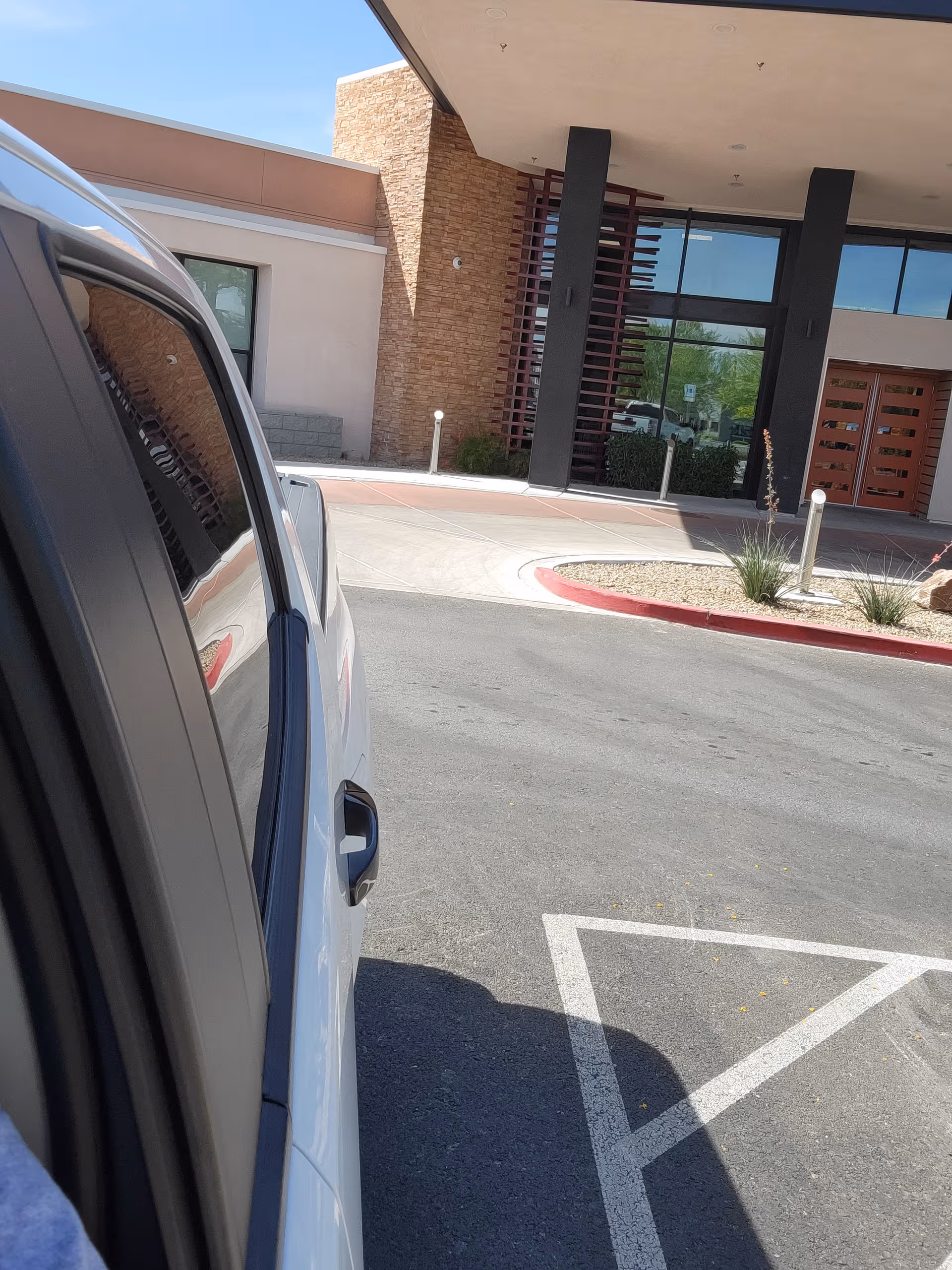 Exterior view of Lumina Las Vegas entrance with brick facade and a parked vehicle.