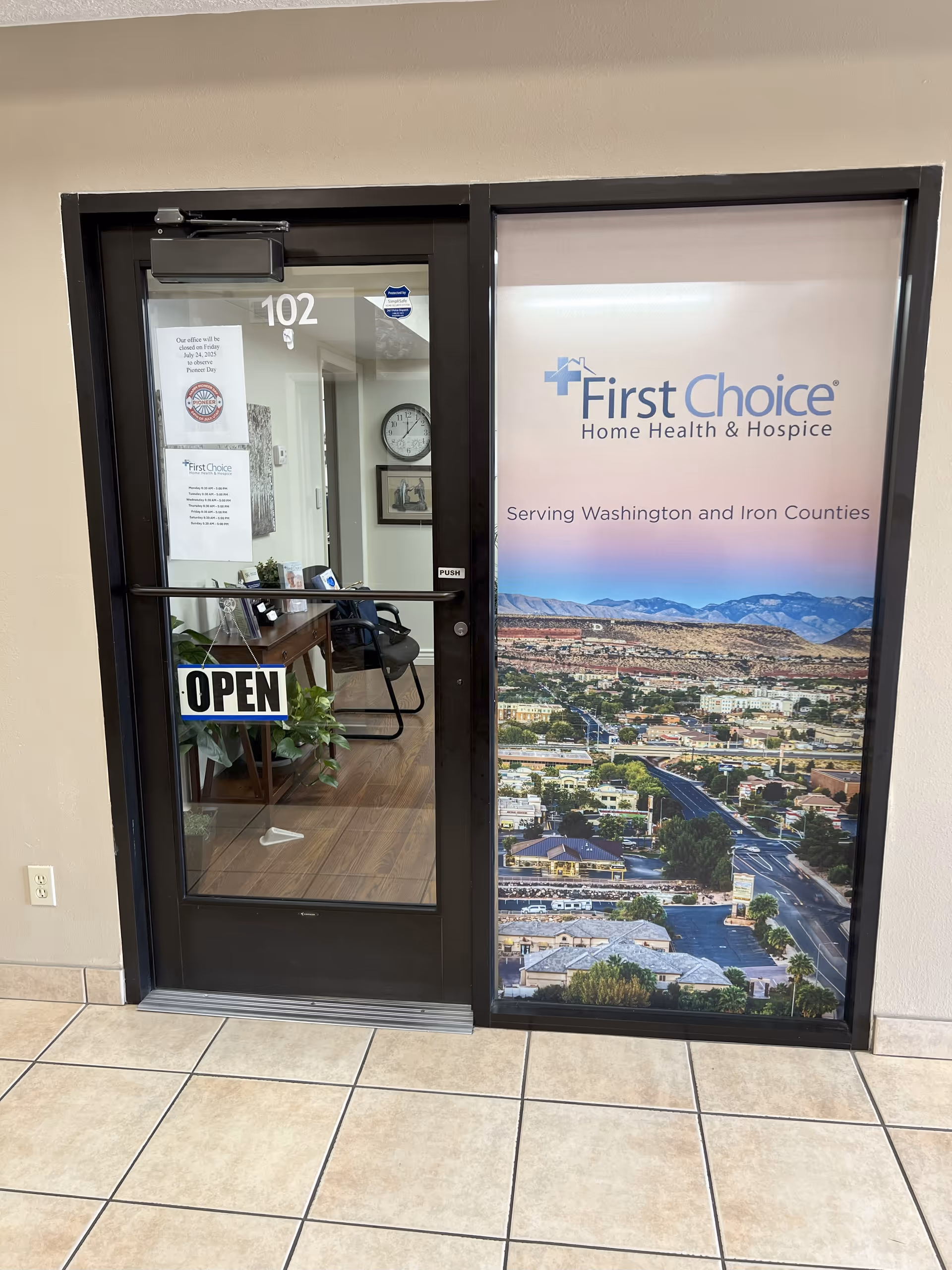 Glass door with OPEN sign, hallway interior, and a First Choice Home Health banner.