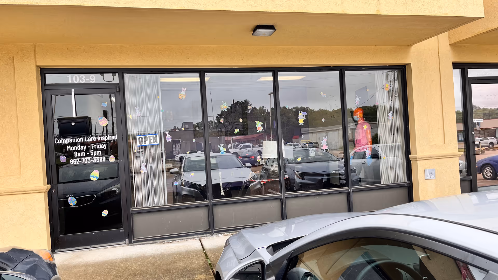 Front view of Companion Care Inspired storefront with glass windows and parked cars.