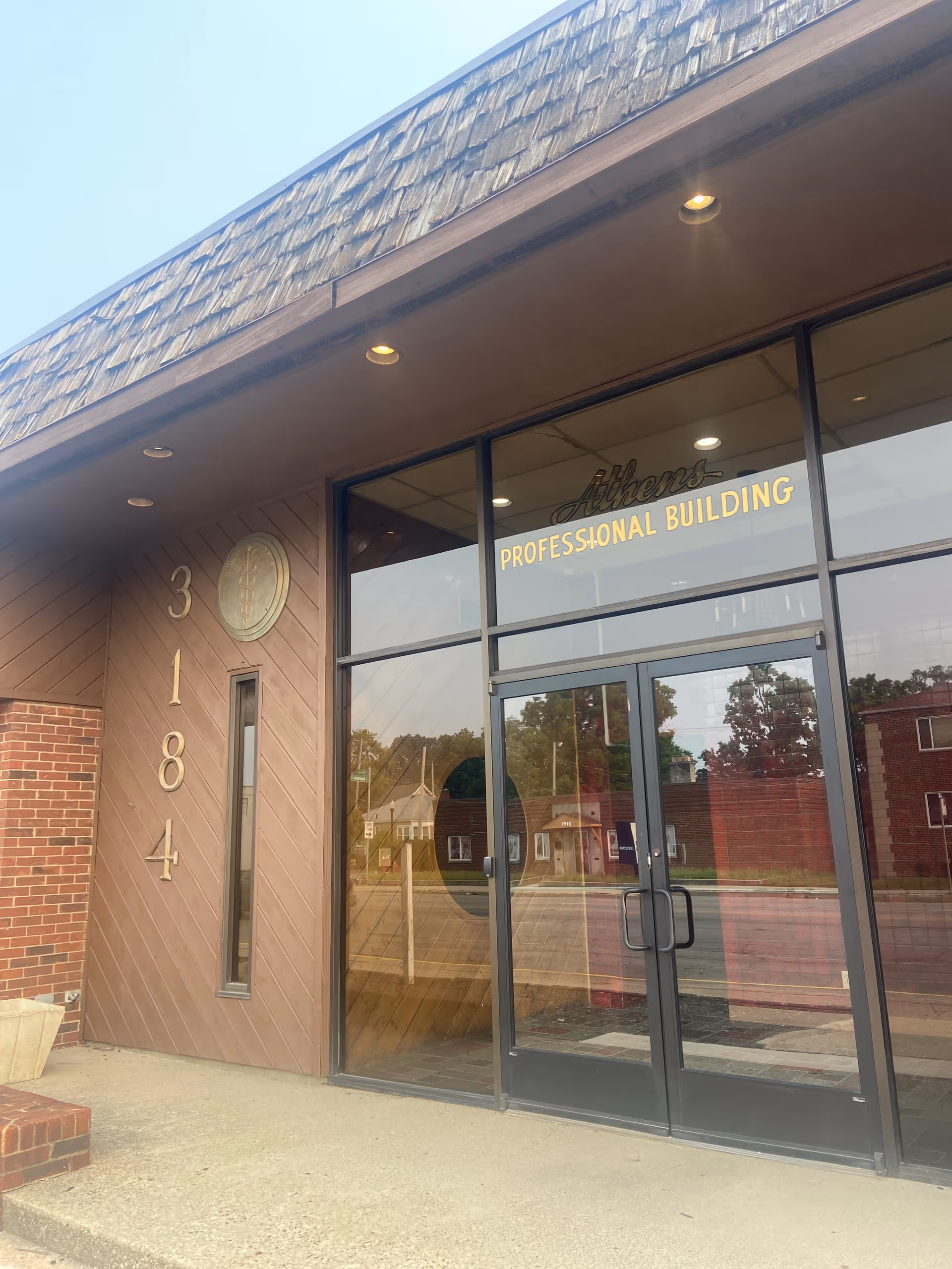 Exterior view of a building entrance with glass doors and gold lettering.
