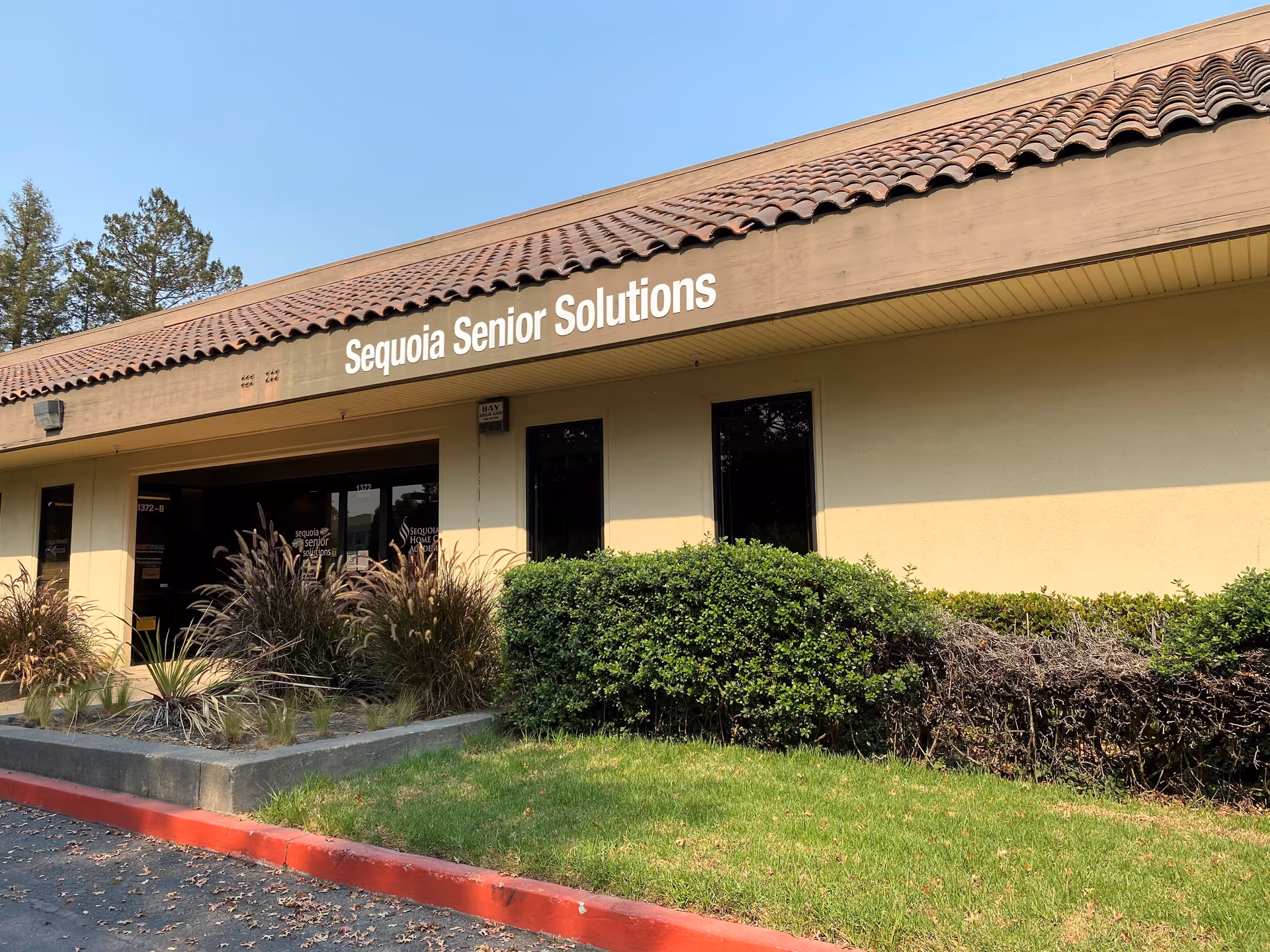 Front exterior of Sequoia Senior Solutions building with sign and landscaping