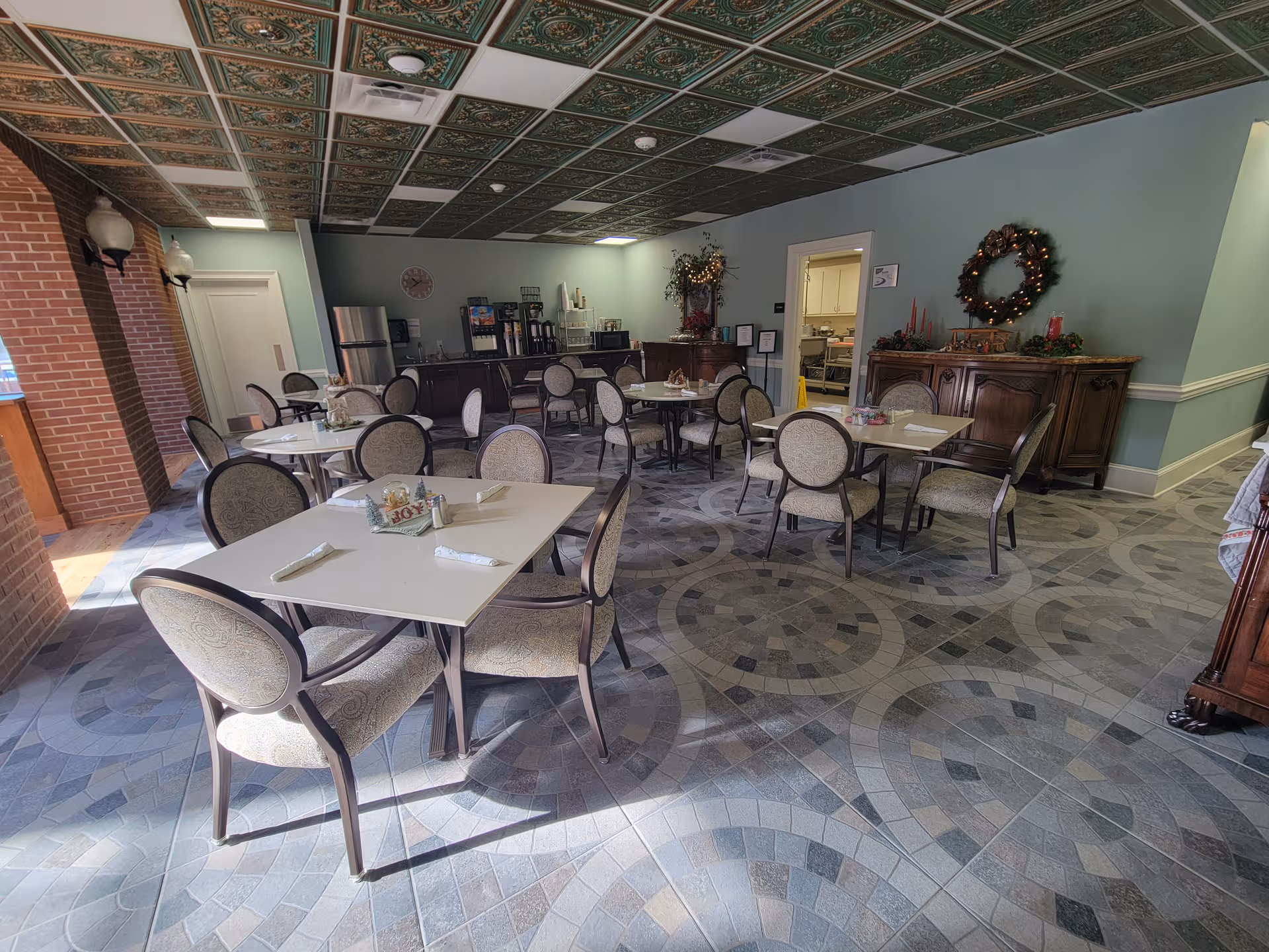 Dining room at The Madison Assisted Living with tables, chairs, and festive decor.