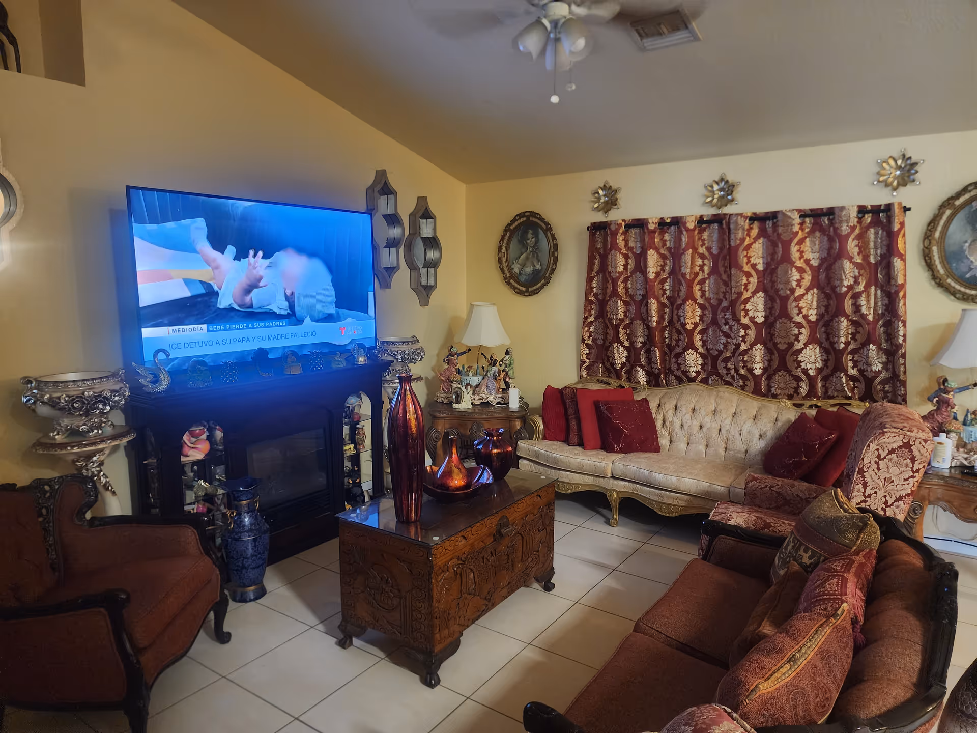 Cozy living room with plush sofas, ornate furniture, and a large flat screen TV.