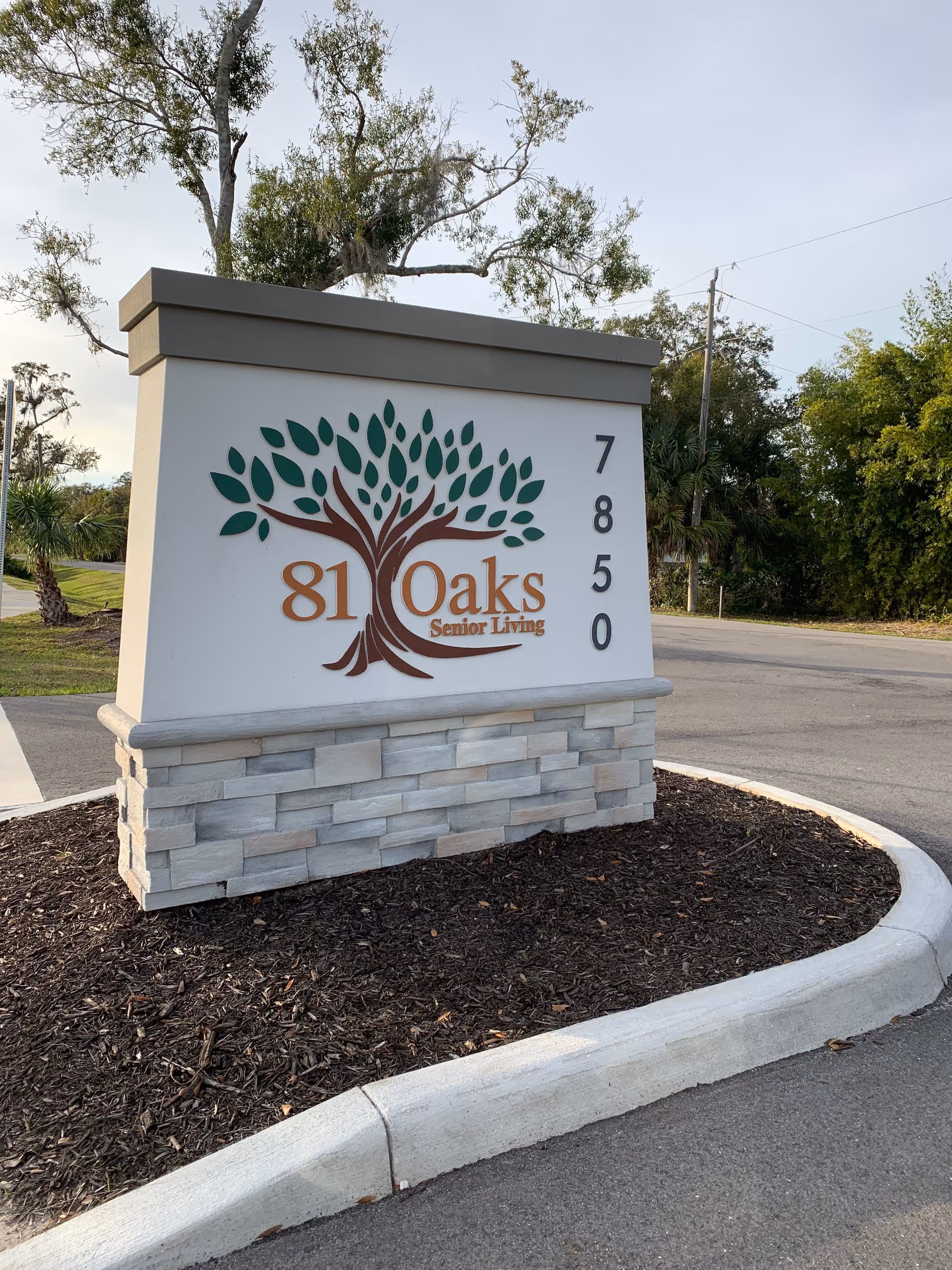 Front sign for 81 Oaks Senior Living featuring a tree logo.