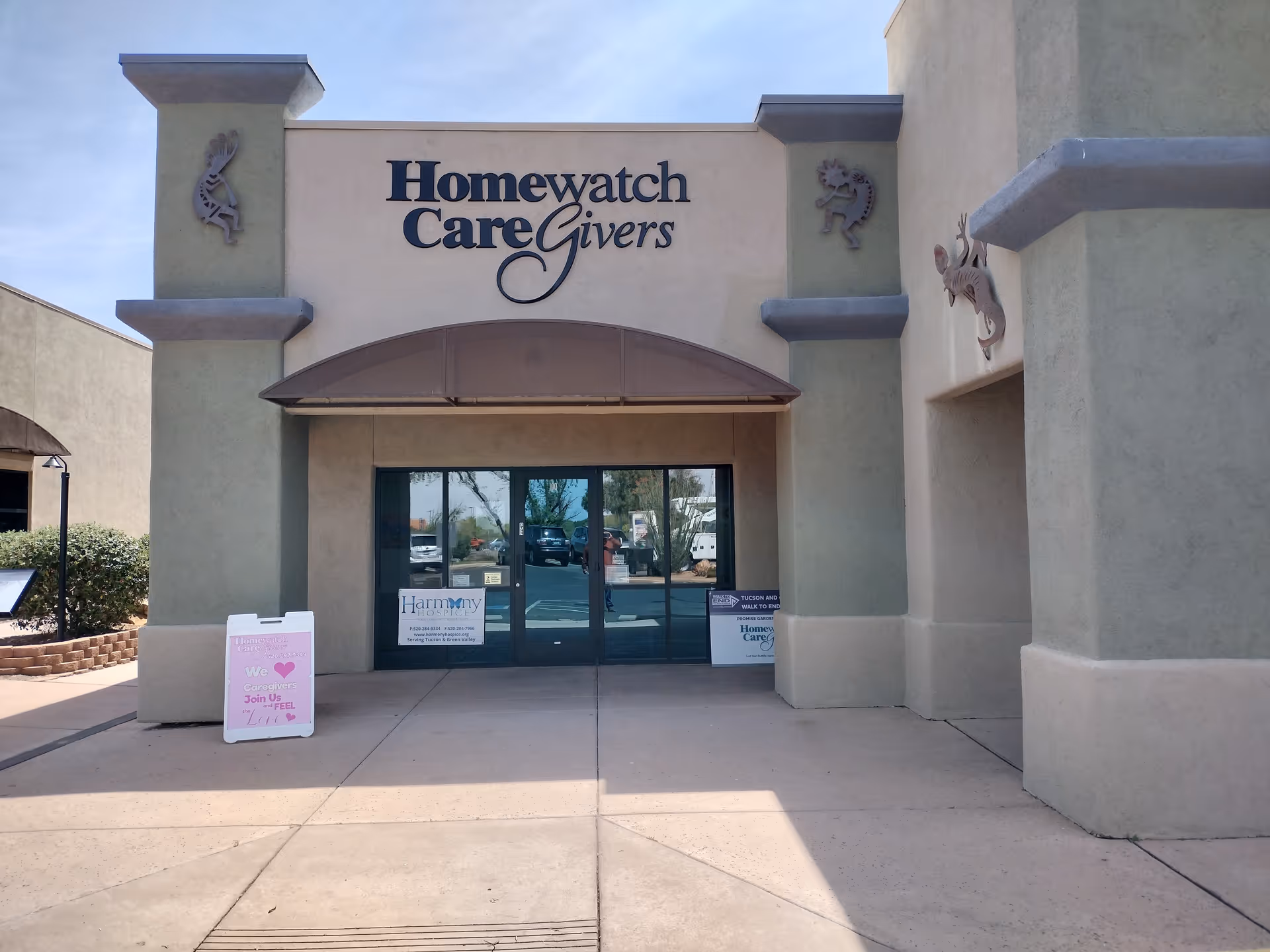 Front entrance of Homewatch CareGivers building with glass doors and sign.