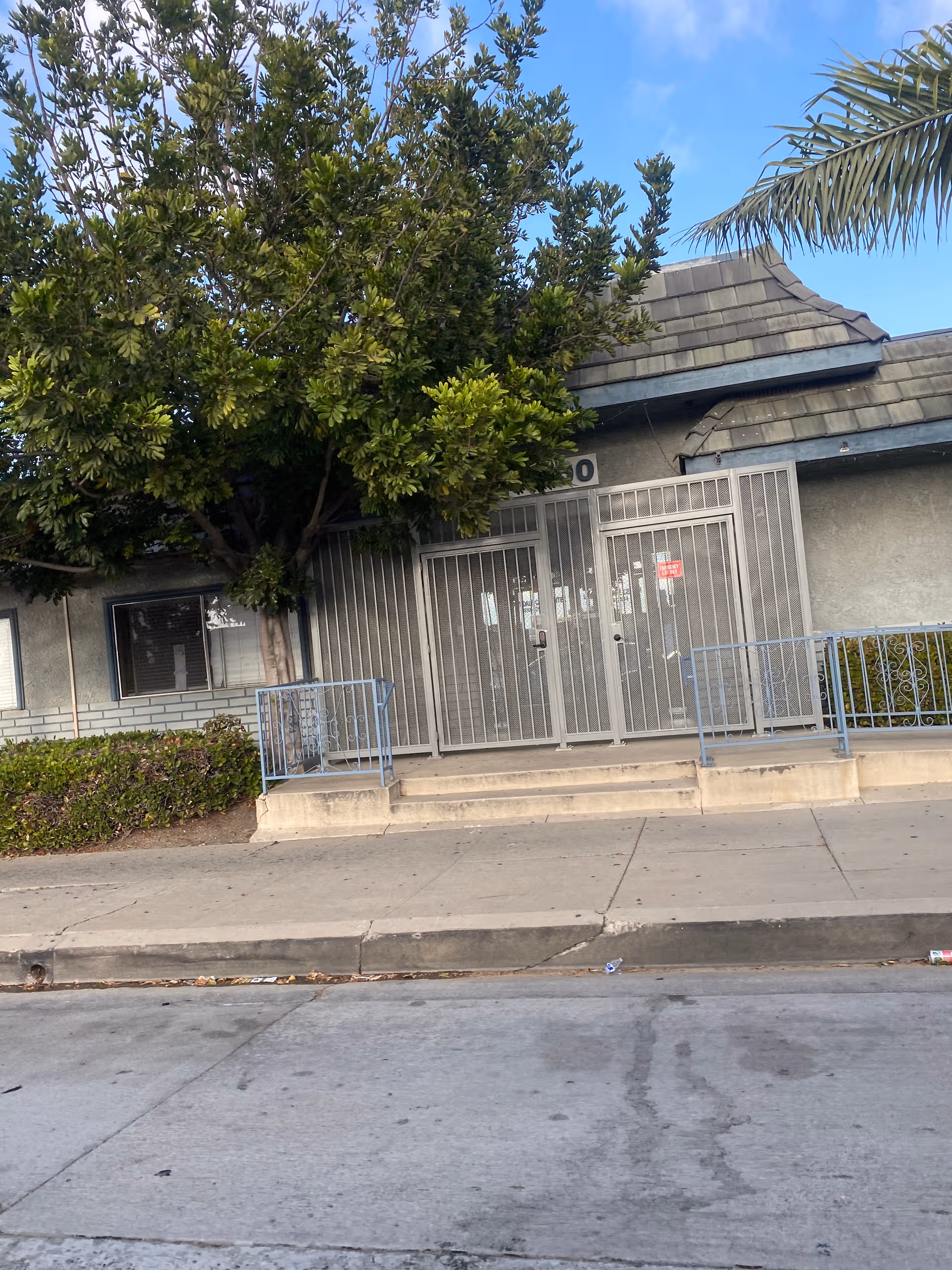 Front exterior view of Americare Assisted Living entrance with metal gate and steps.