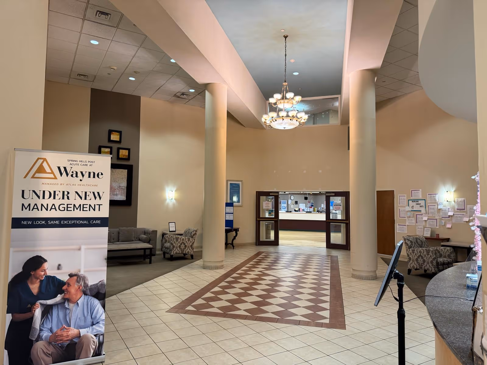 Atrium Post Acute Care of Wayne lobby with seating, chandelier, and reception desk.