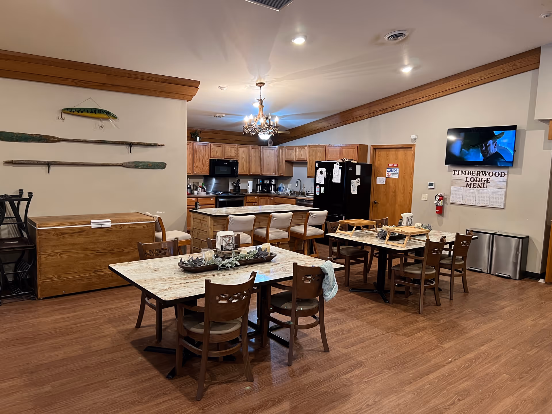 Communal dining area with marble table, chairs, island, and wooden cabinetry.