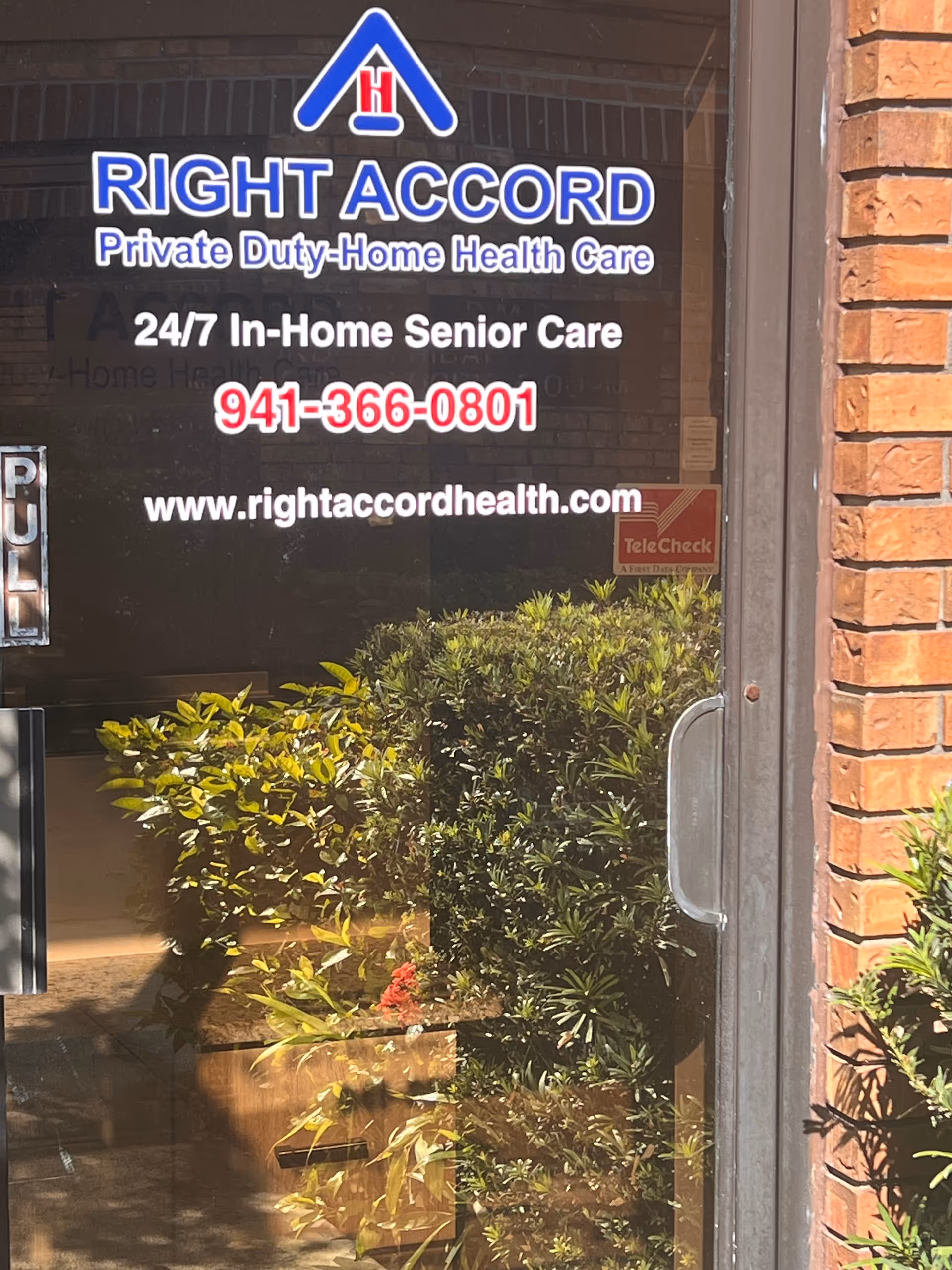 Front entrance of Right Accord Home Health Care Venice with blue sign and shrubs.