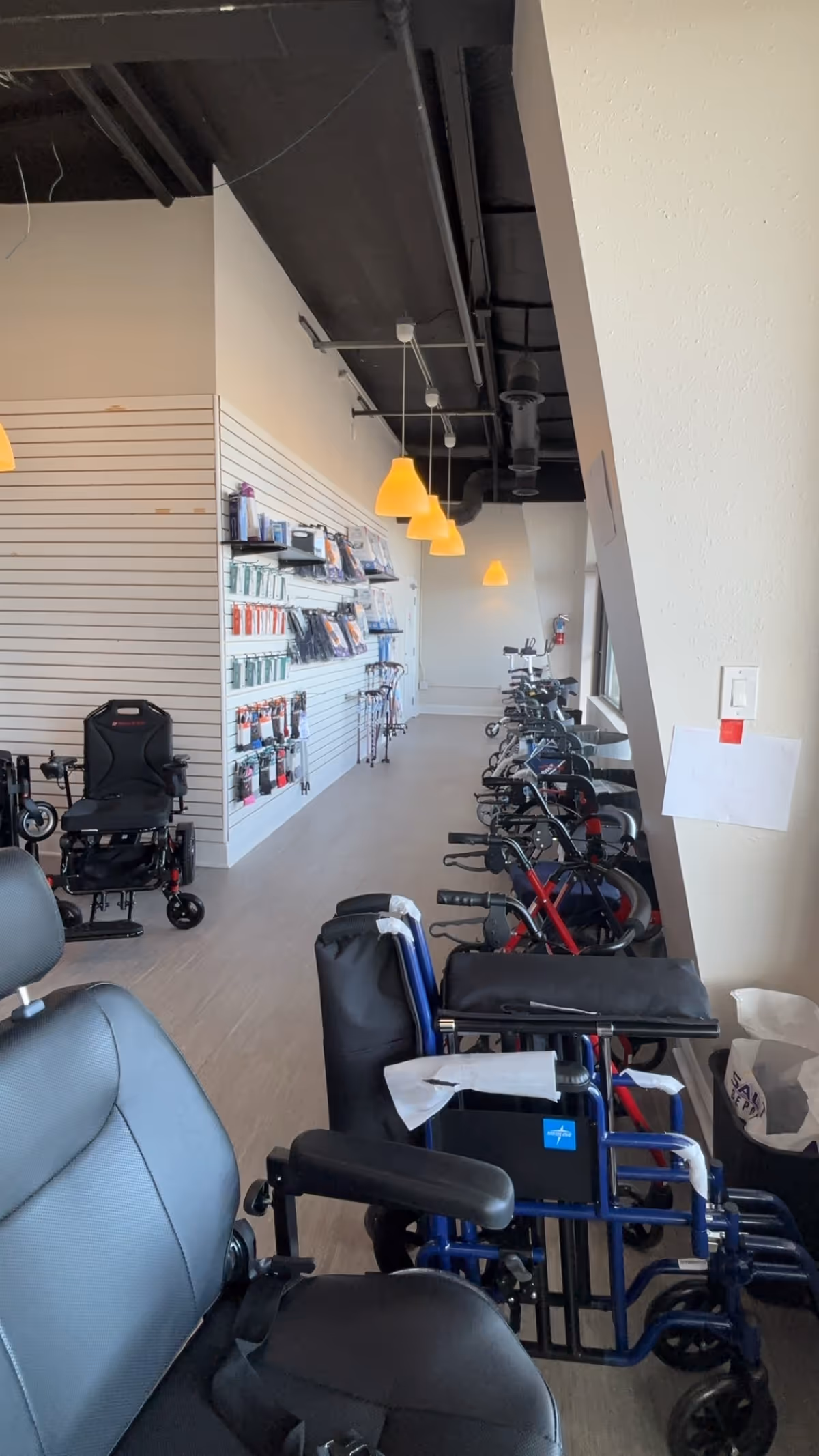 Indoor showroom with wheelchairs, walkers, and medical supplies displayed along a wall.