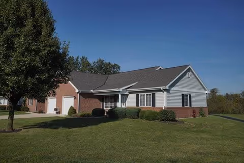 Exterior view of a single-story brick-and-siding facility with a manicured lawn.