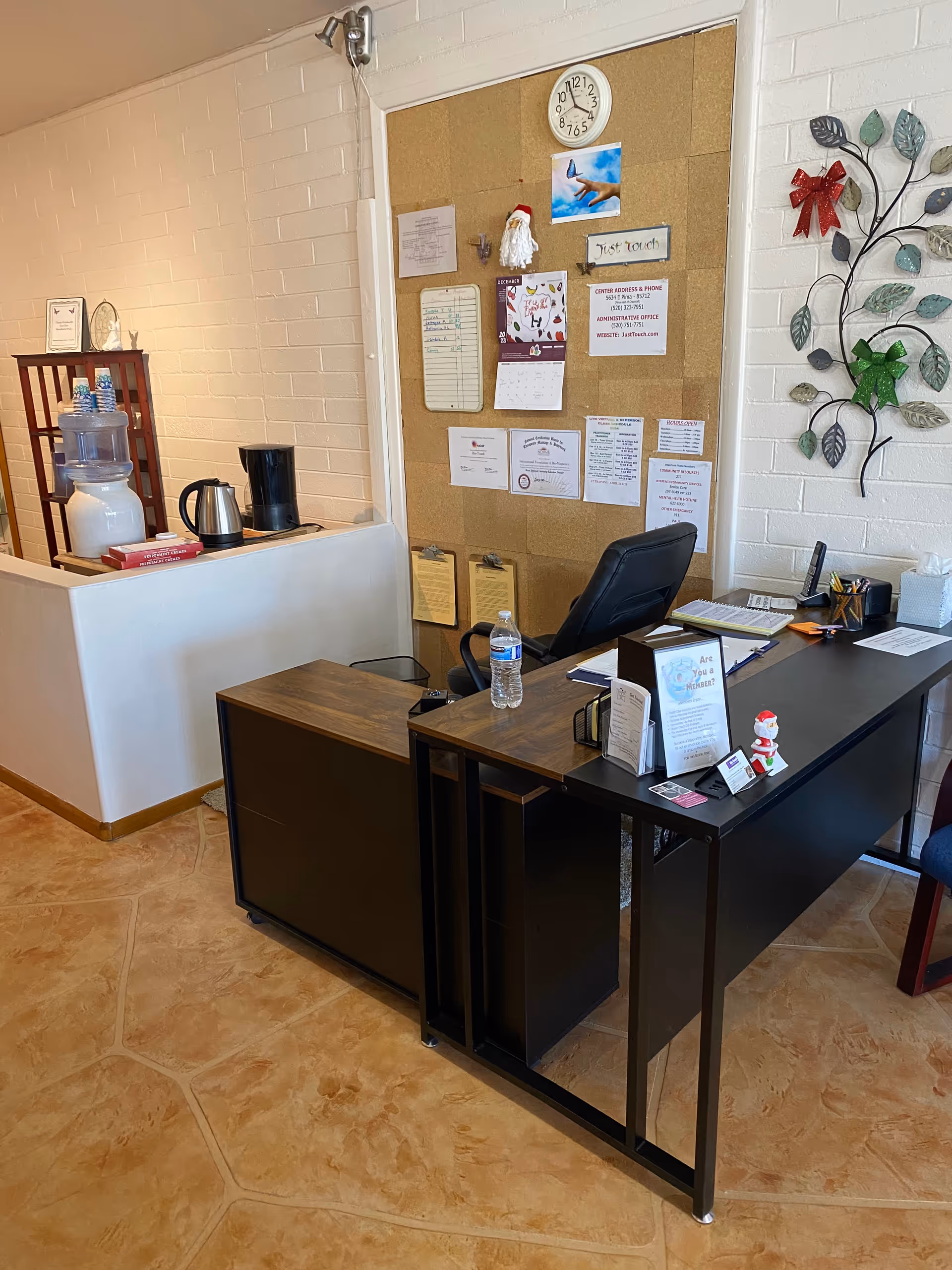Reception desk with corkboard wall and clock in a senior living facility lobby.