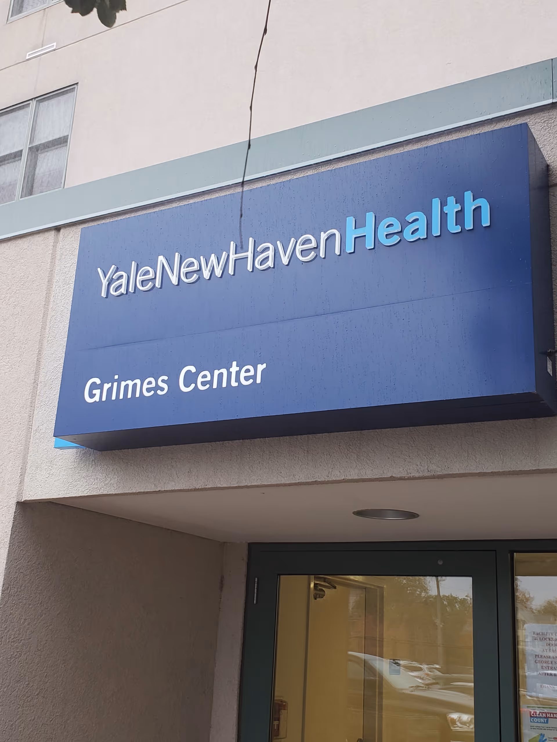 Blue YaleNewHavenHealth Grimes Center sign on beige building exterior