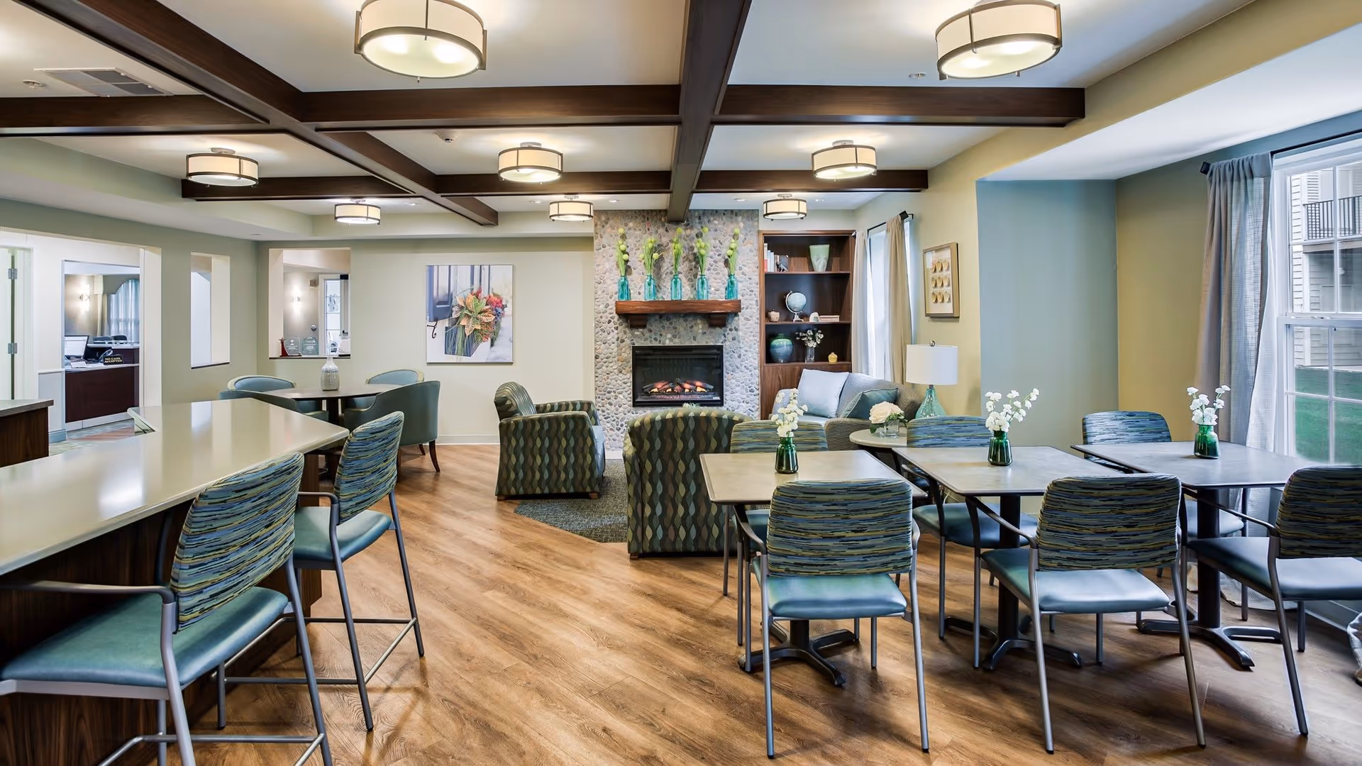 Spacious communal living area with tables, chairs, a fireplace, and lounge seating.