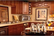 Warm wood kitchen in a senior living facility, with cabinets, microwave, and beverage service.