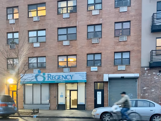 Brick building facade with Regency Health Care sign and glass entrance.