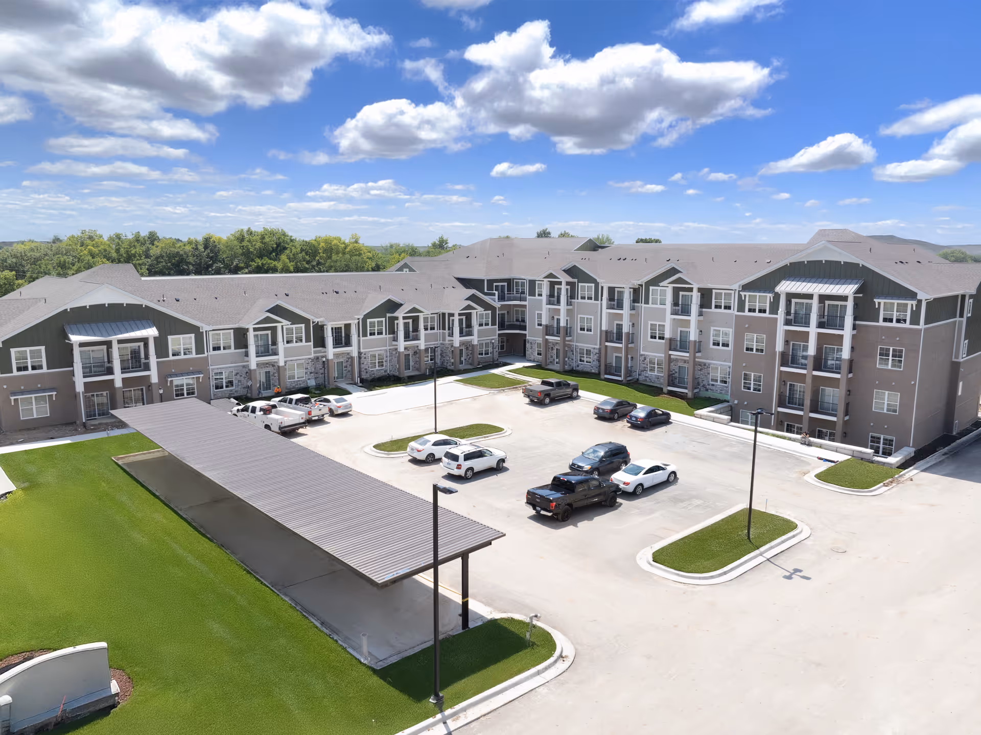 Aerial view of a multi-building senior living campus with a parking lot and green grounds.