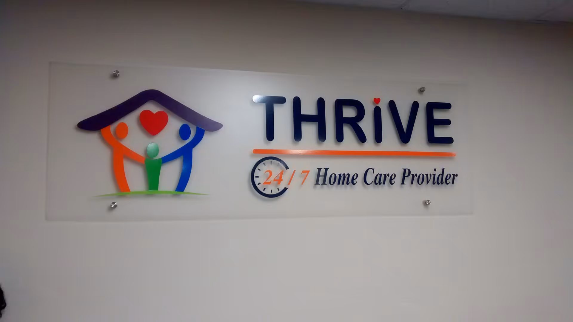Interior wall sign displaying Thrive Home Care Provider with colorful logo.