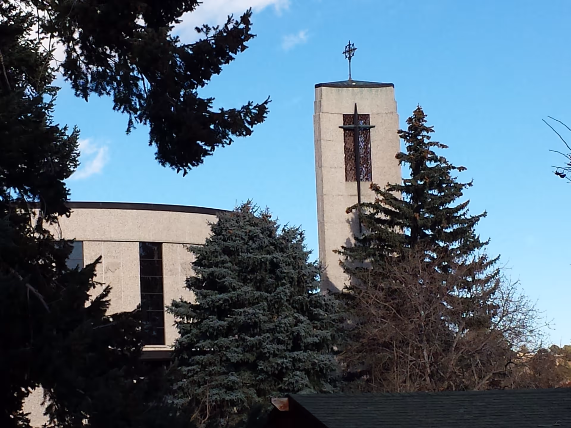 Exterior view of Mount St Francis Nursing Center with a cross-topped tower and trees.