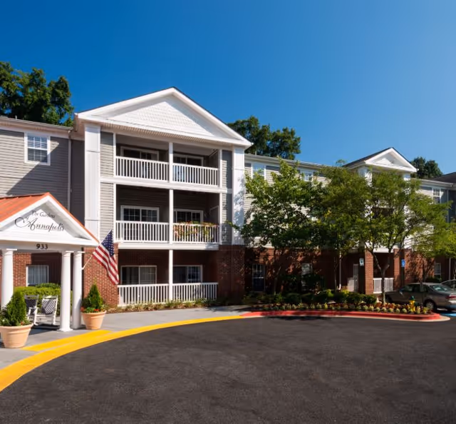 Exterior view of The Gardens of Annapolis senior living facility with balconies and entrance.