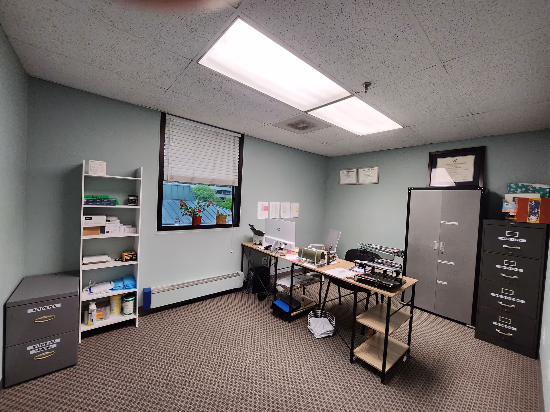 Office space inside a senior care facility with desks, filing cabinets, and a window.