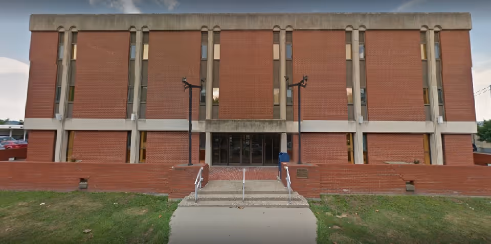 Exterior view of a brick facility with a central entrance and steps.