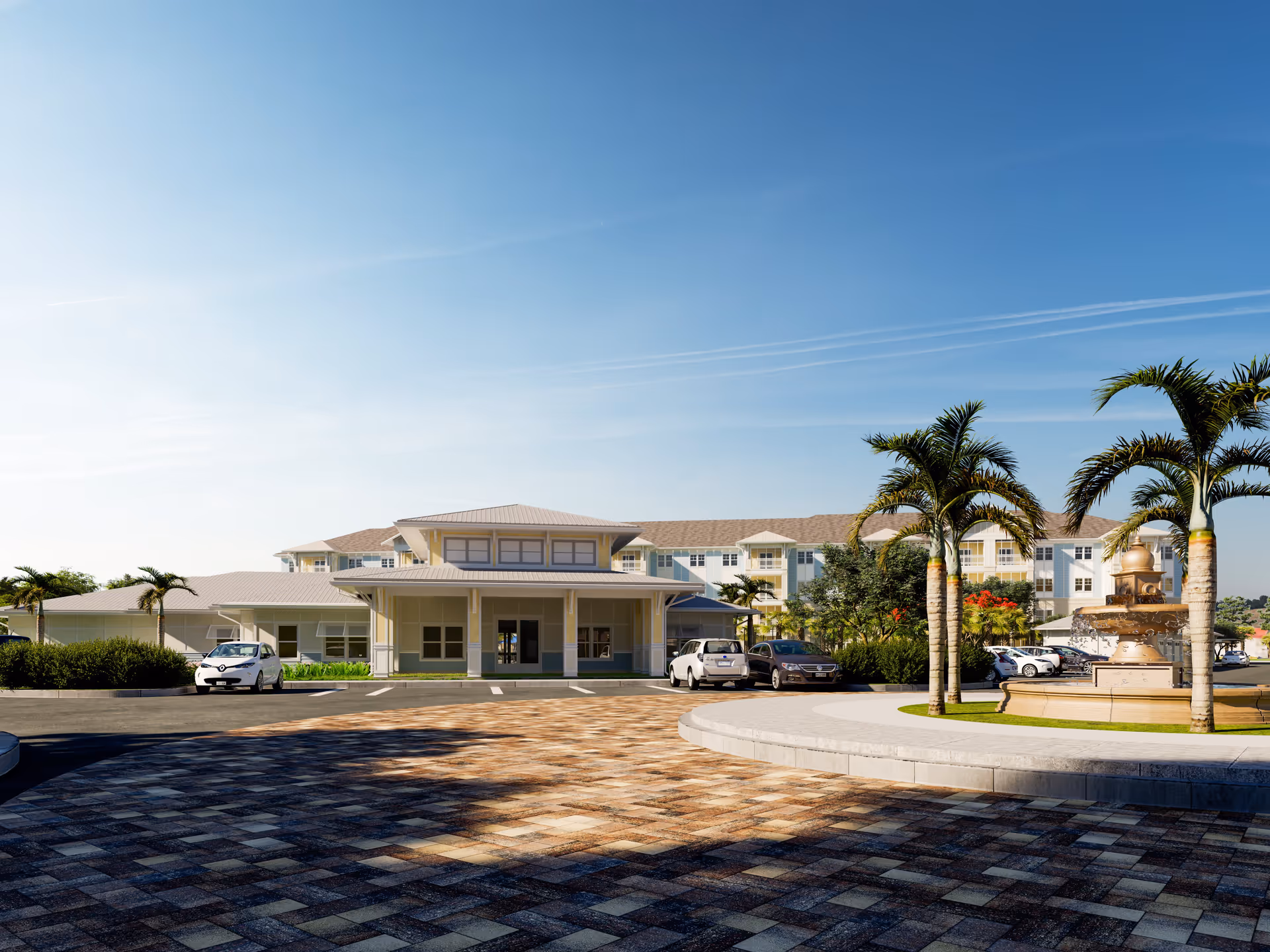 Exterior view of The Sovana At Stuart senior living facility showing a large building with multiple windows and balconies, a paved circular driveway with a fountain surrounded by palm trees, several parked cars, and a clear blue sky.