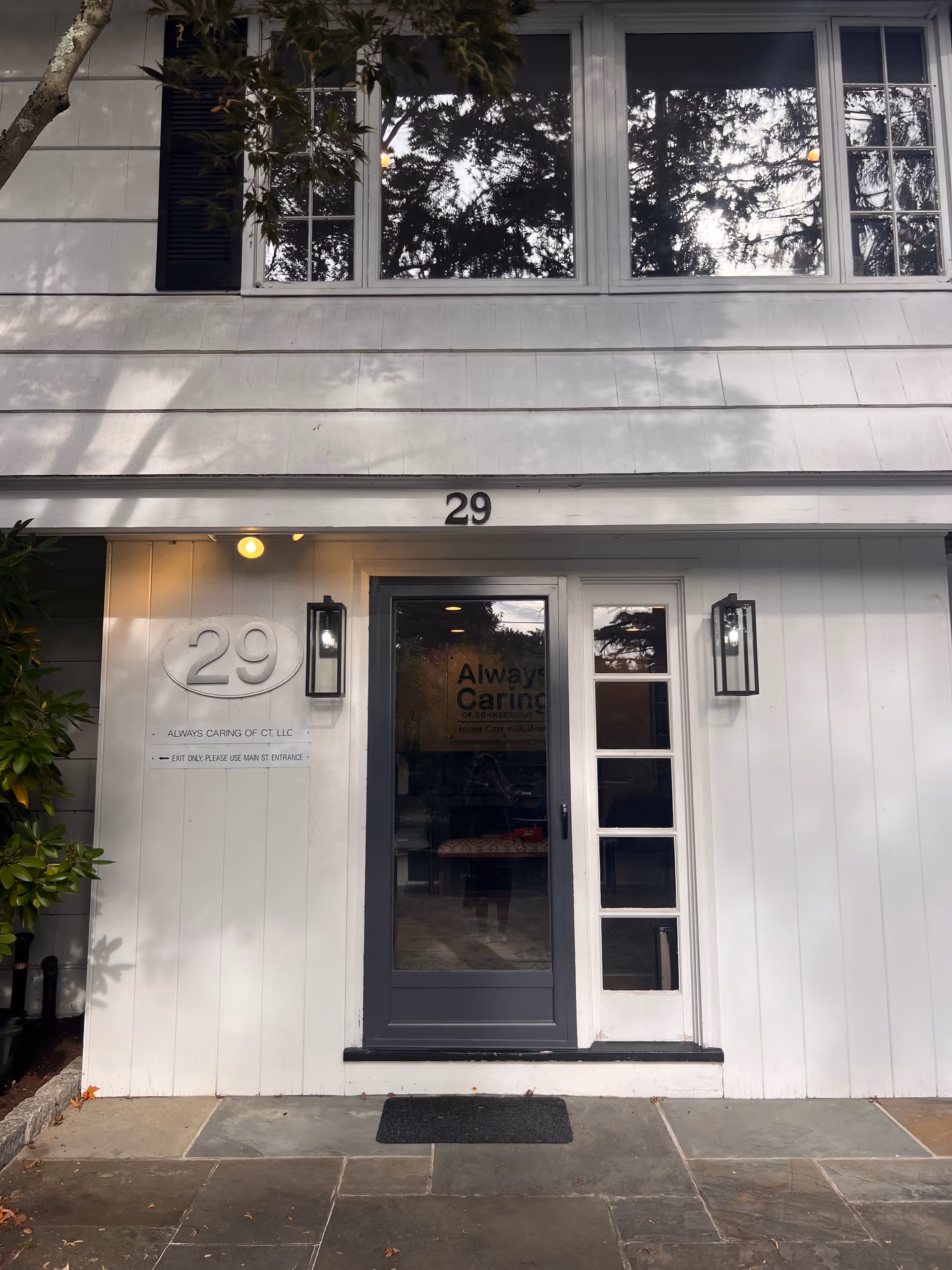 White building exterior with front entrance, door numbered 29, and Always Caring signage visible.