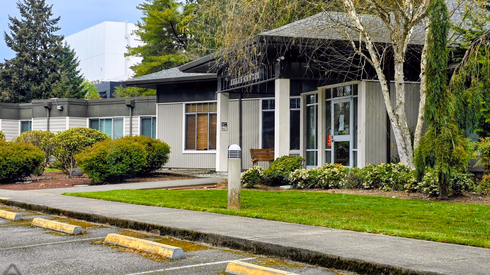 Front exterior view of Orchard Park Health and Rehabilitation Center with entrance, walkway, and landscaping.