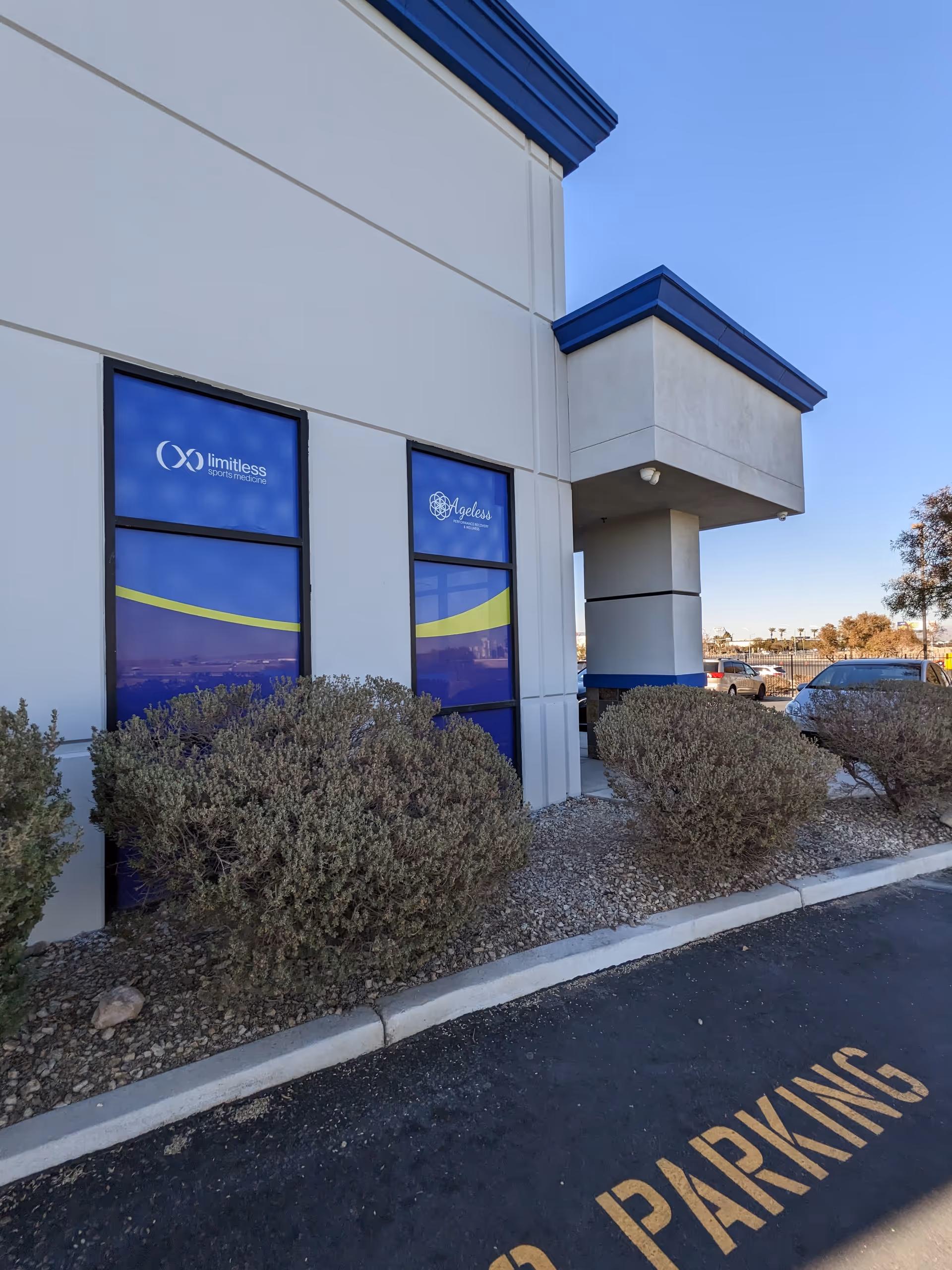 Exterior view of Limitless Sports Medicine & Physical Therapy building with shrubs and parking lot.