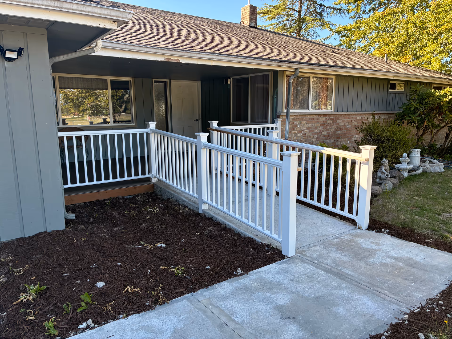 Front exterior of a single-story senior living home with a white railing ramp.
