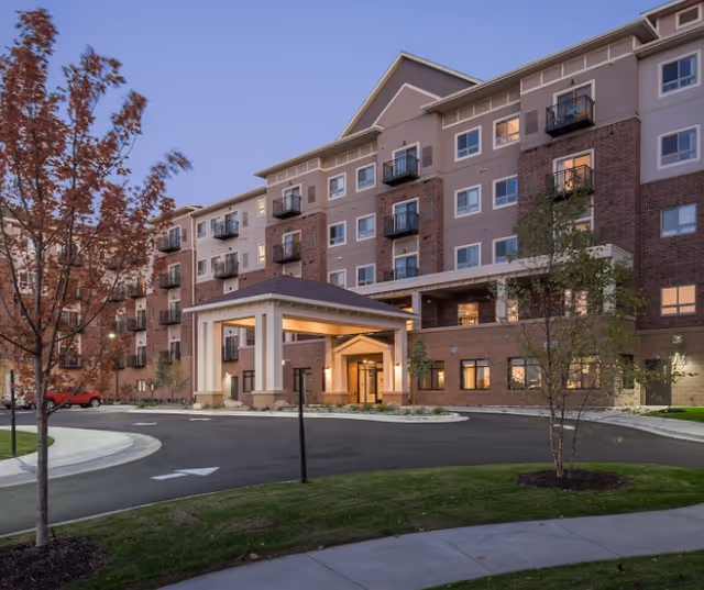 Exterior view of Affinity At Eagan, a multi-story senior living building with a covered entrance.