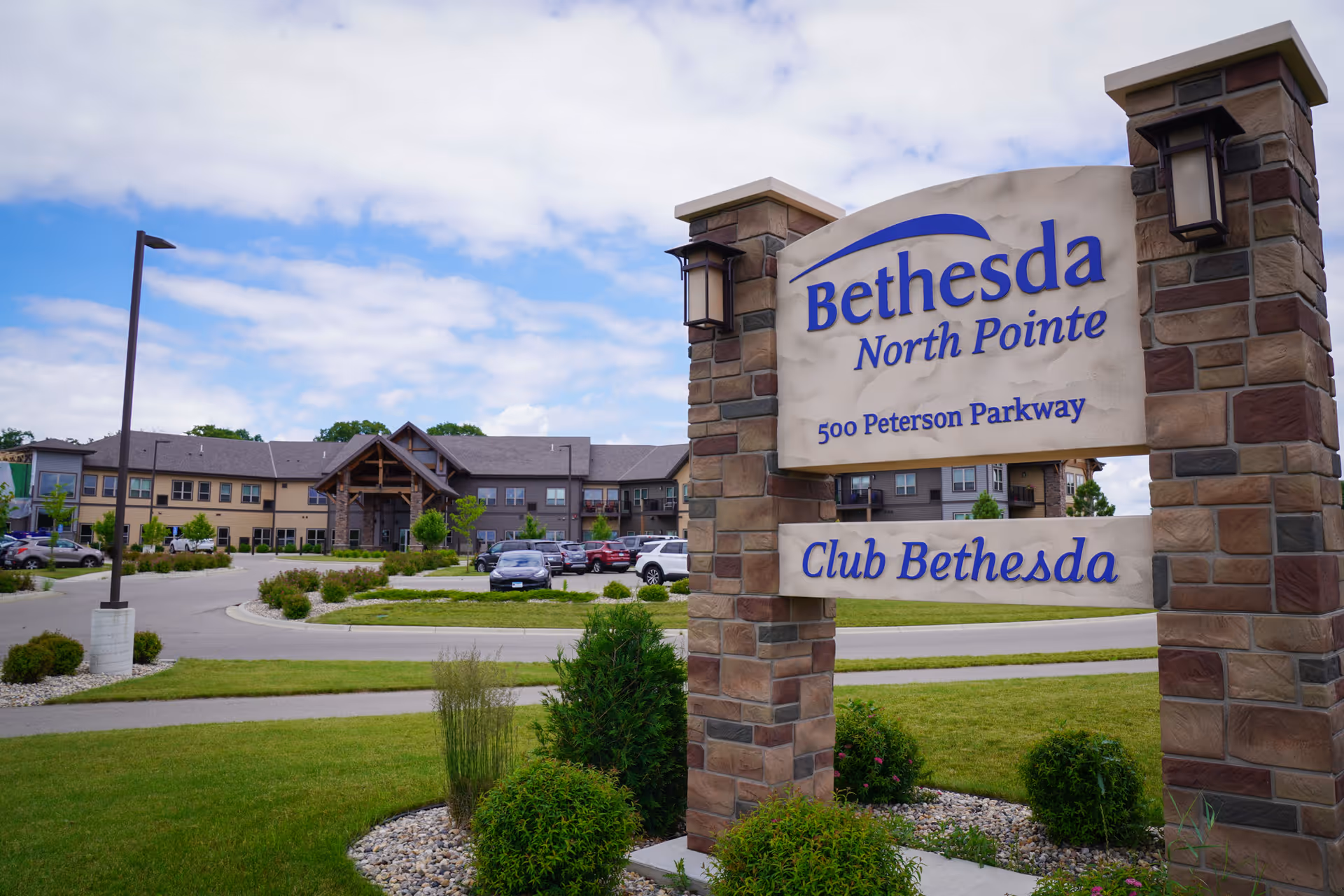 Bethesda North Pointe exterior sign with building and landscaped drive in the background.