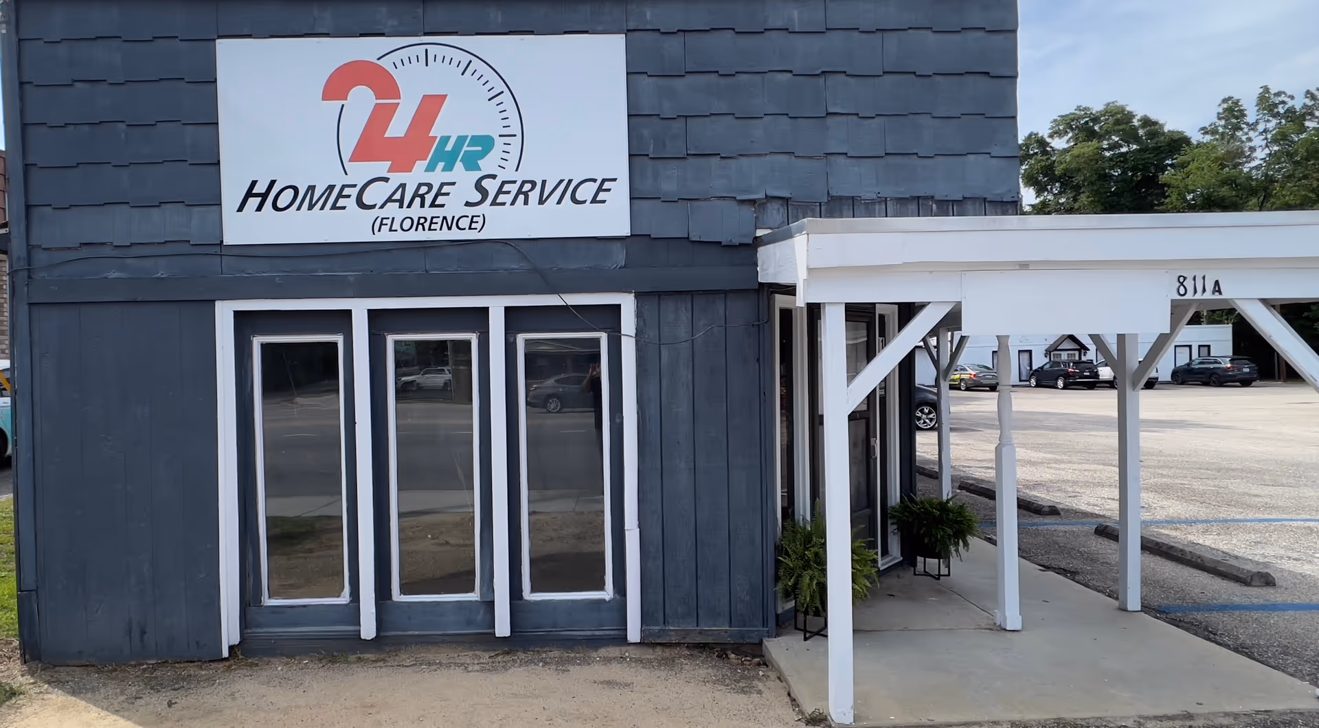 Exterior view of a blue building with a 24HR Home Care Services Florence sign and entrance