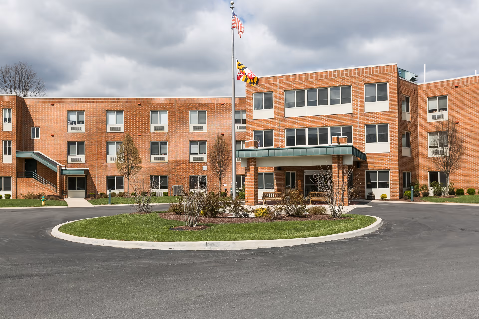 Exterior view of Devlin Manor Nursing and Rehabilitation Center, a brick building with driveway and flagpole.
