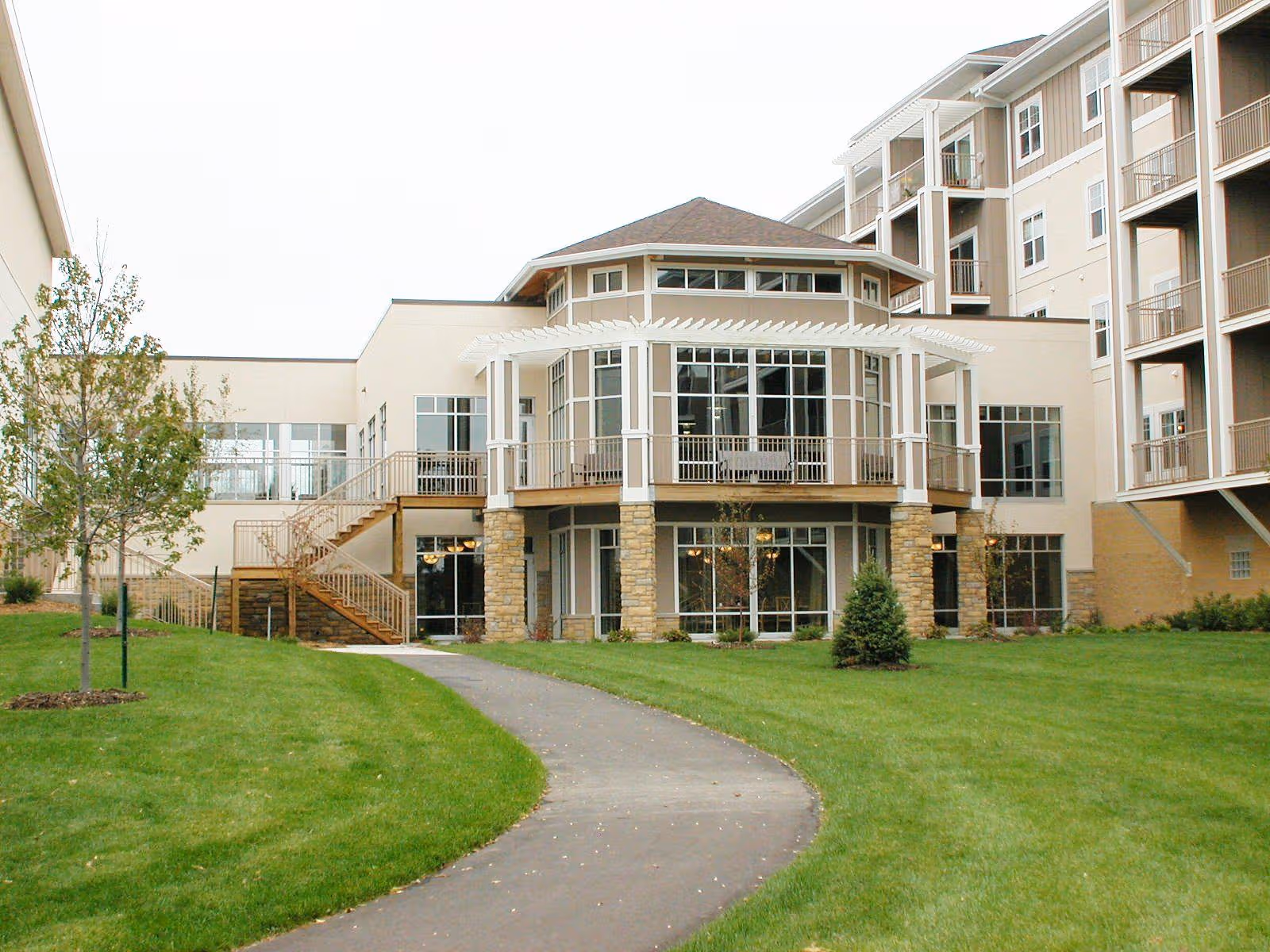 Exterior view of McKenna Crossing showing a multi-story building, glass atrium, and green lawn