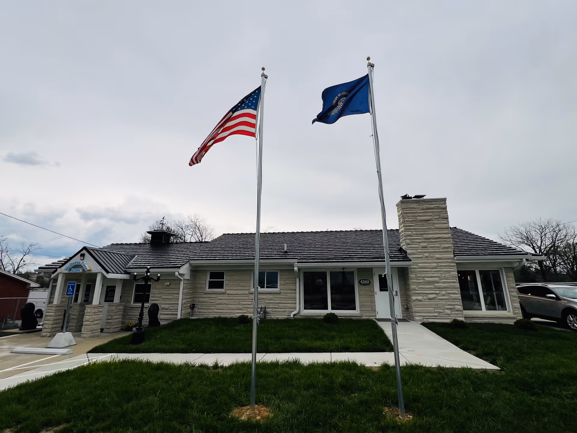 Single-story stone-faced senior facility with two flagpoles and a visible front entrance.