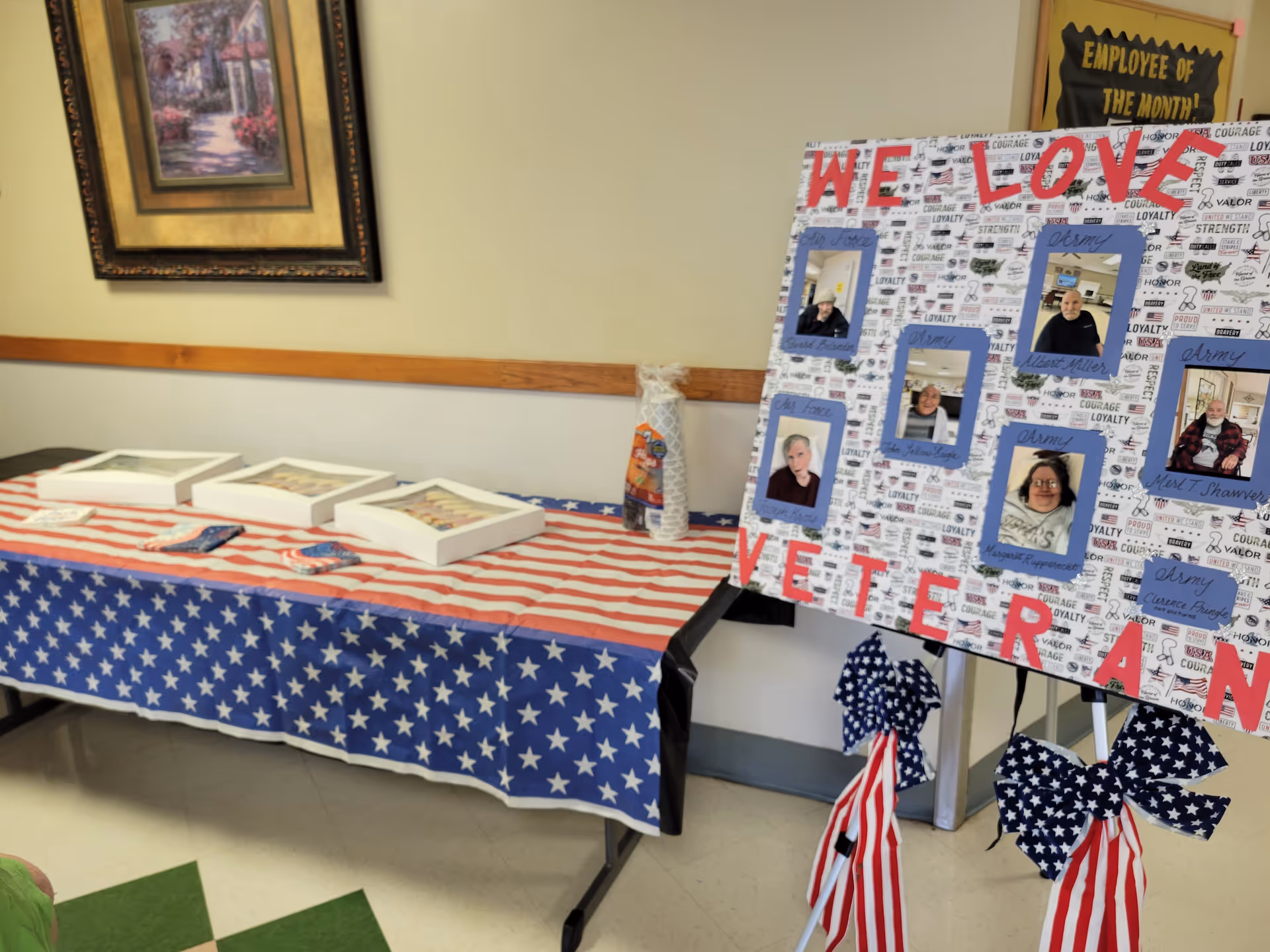 Patriotic display table with American flag tablecloth and a veteran tribute board.