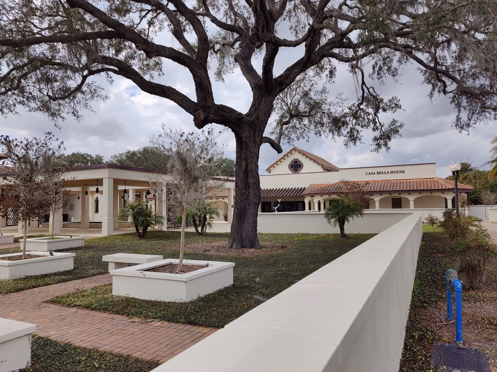 Exterior view of Cornerstone Hospice facility with a large tree and courtyard.