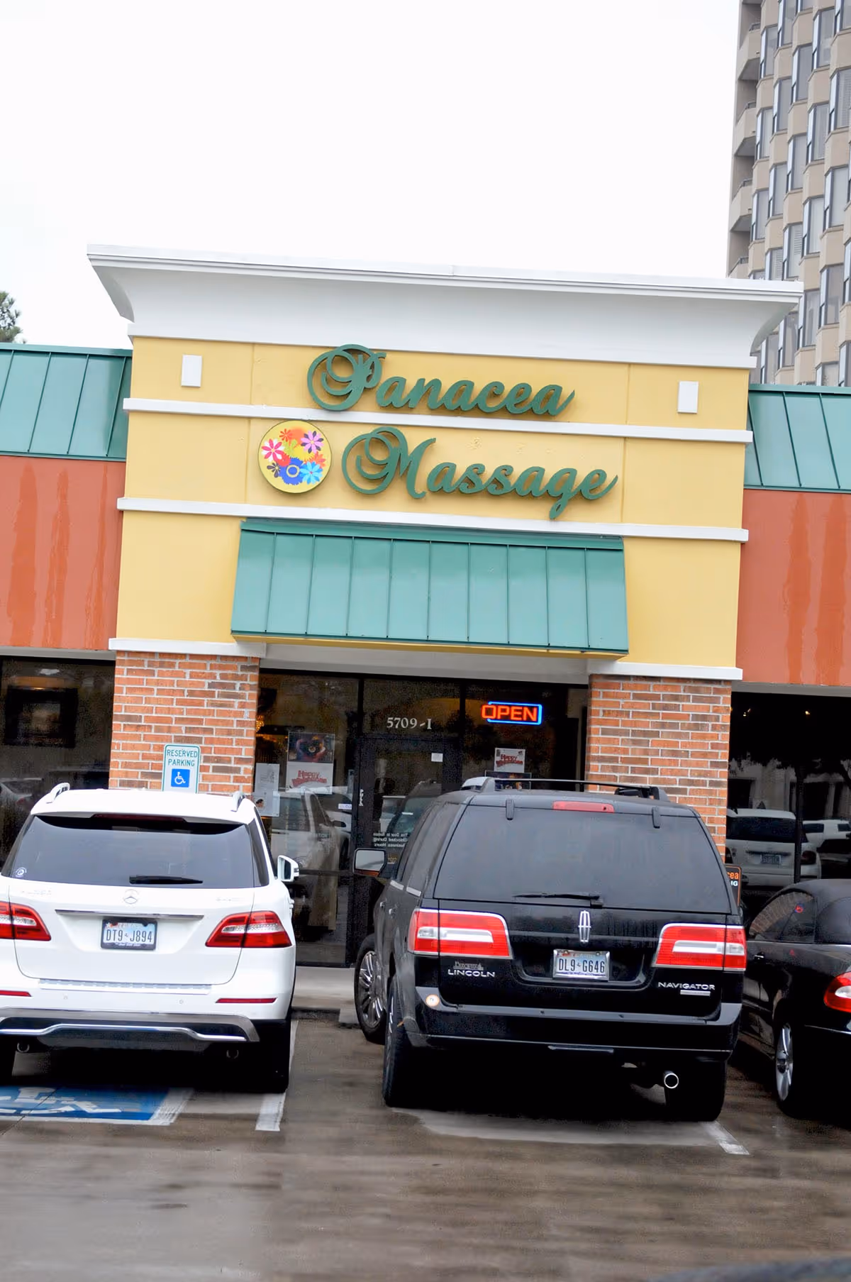 Front exterior of Panacea Massage & Med Spa storefront with parked cars.