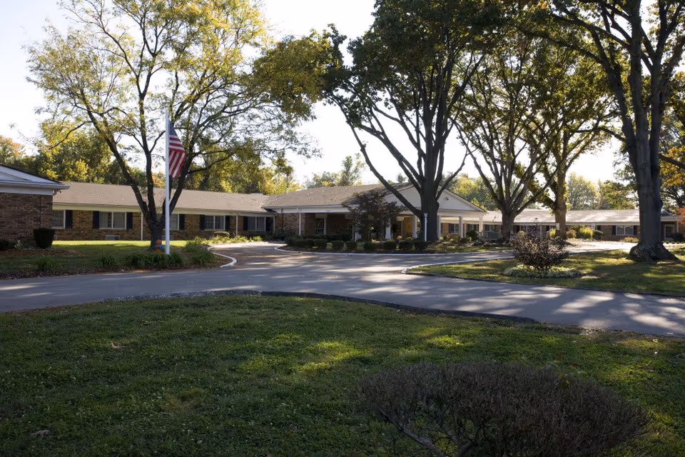 Exterior view of Angels Homes II facility with brick building and large trees.
