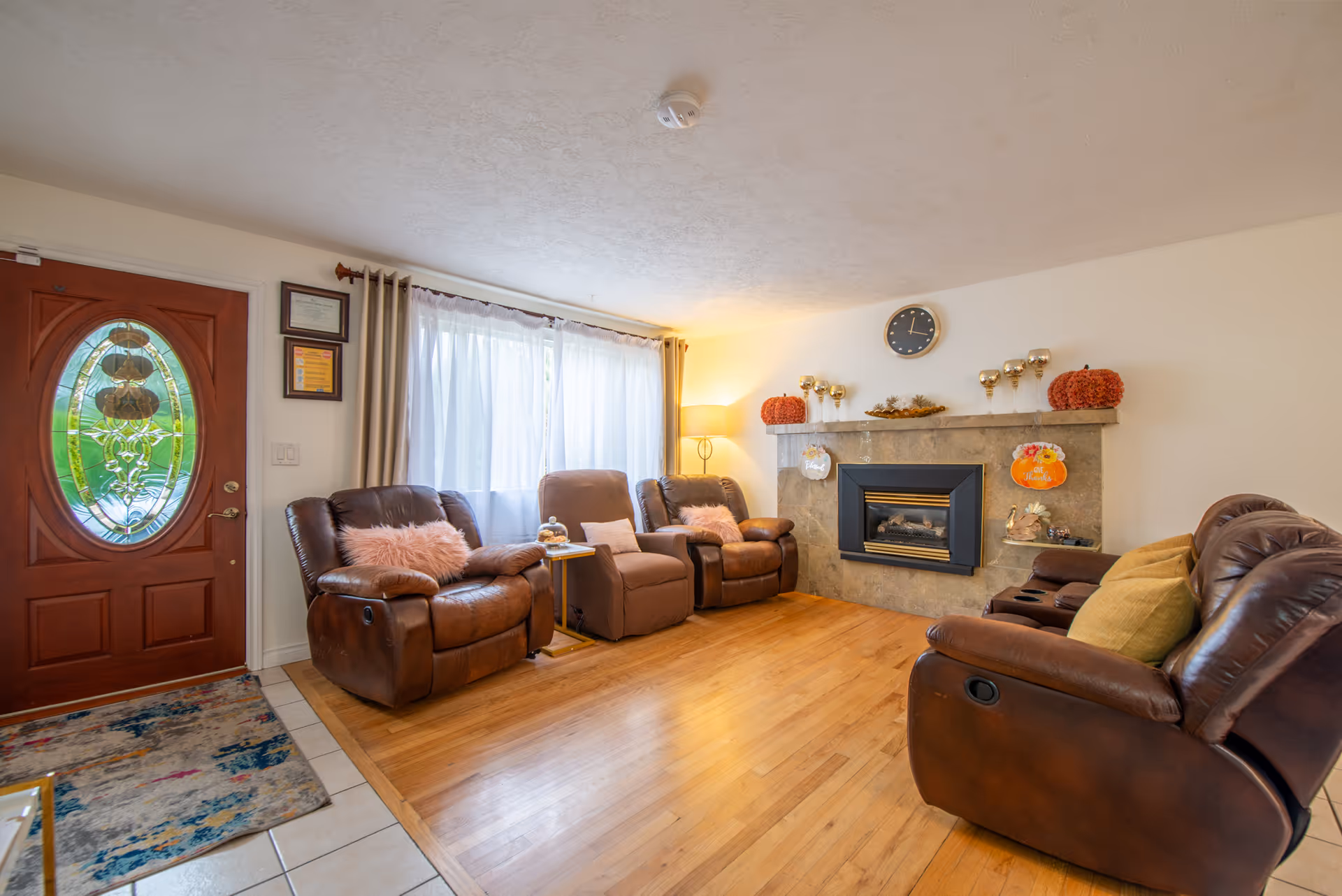 Cozy living room in an elderly home with leather recliners and a decorative fireplace.