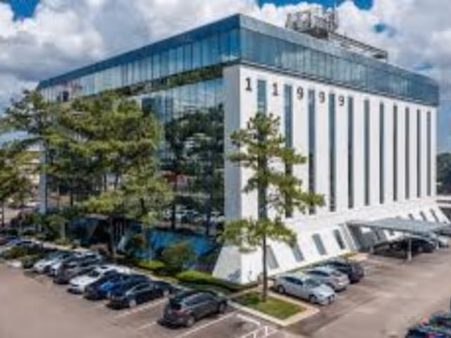 Modern medical facility with tall, white exterior columns and a surrounding parking lot.