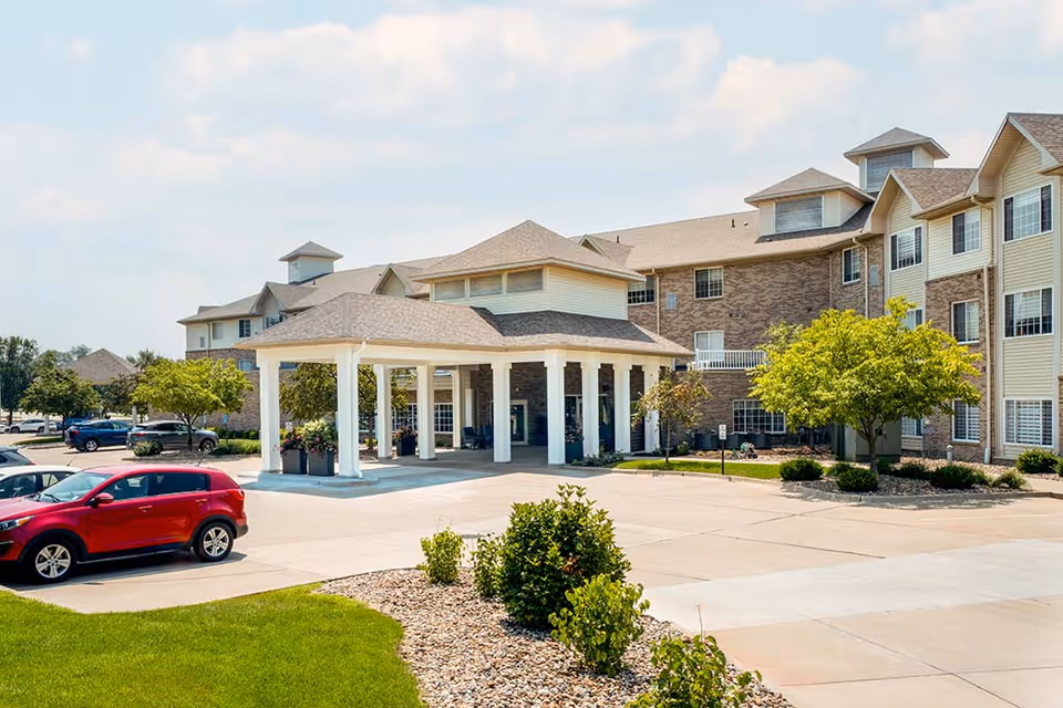 Exterior view of Immanuel: Copper Shores Village showing entrance canopy and parked cars.