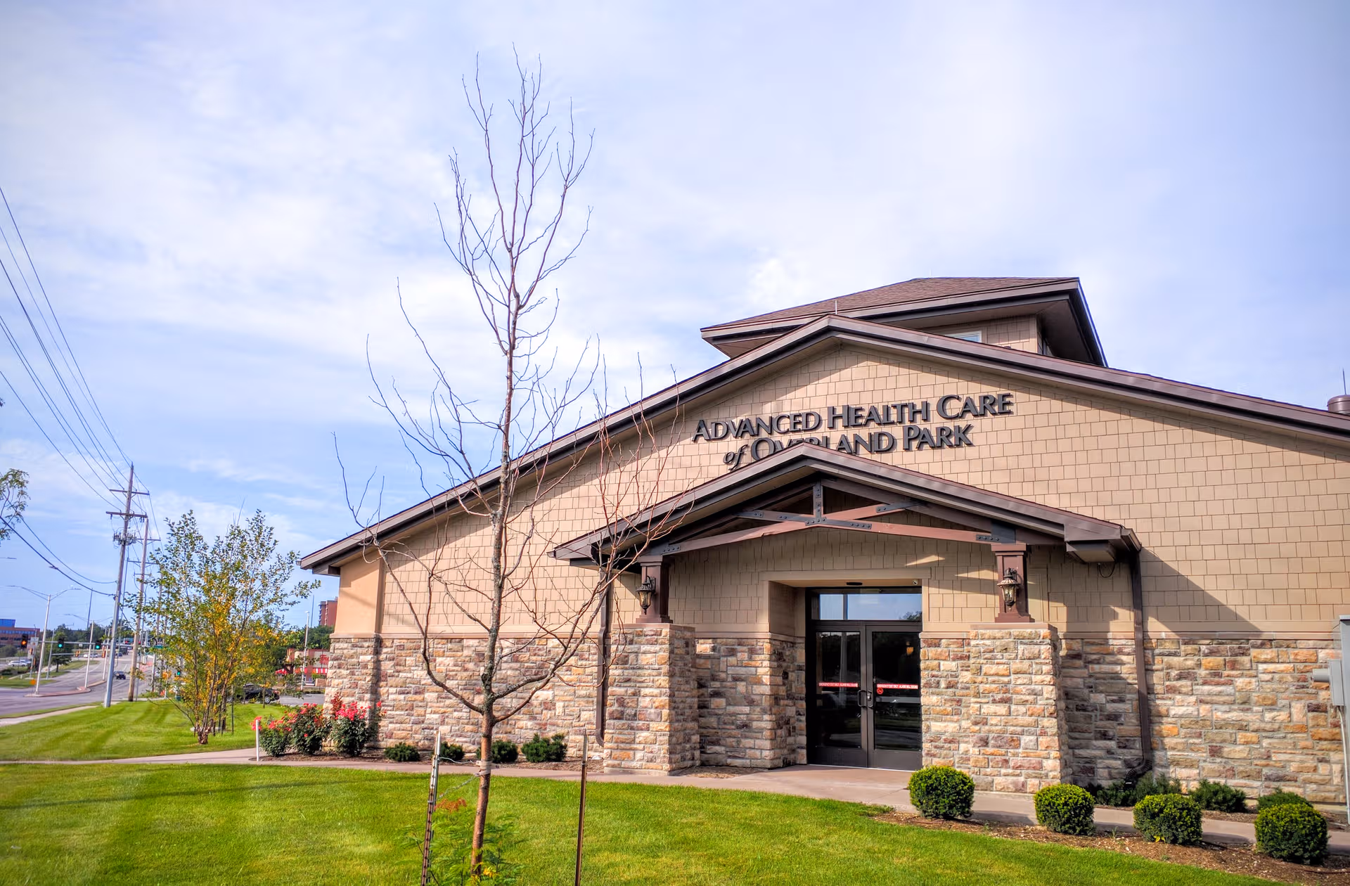 Front entrance of Advanced Health Care of Overland Park with stone facade and landscaping.