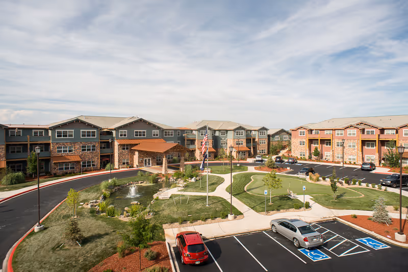 Exterior view of Keystone Place at Legacy Ridge with landscaped courtyards and parking.