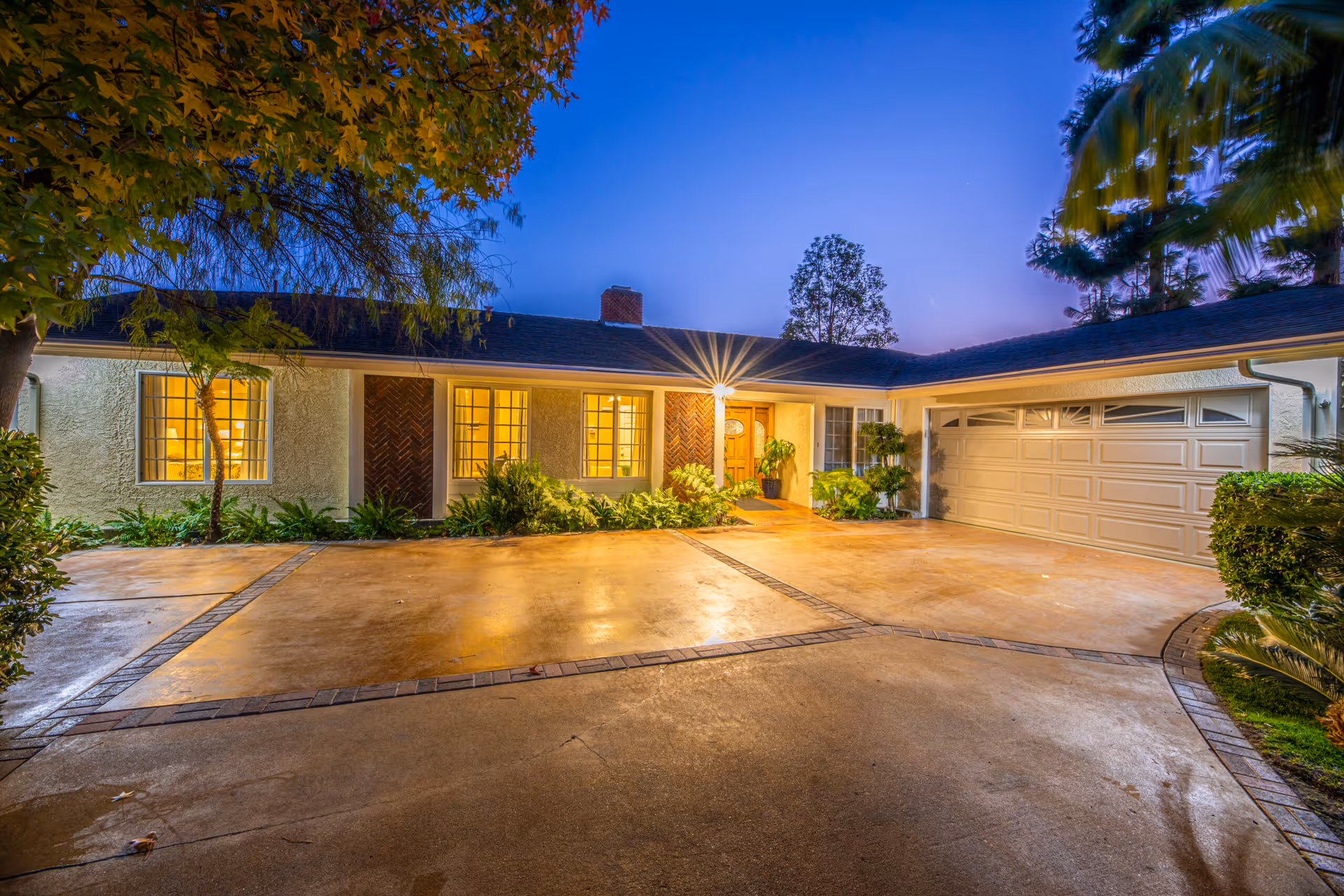 A single-story senior living facility exterior at dusk with a driveway and garage.